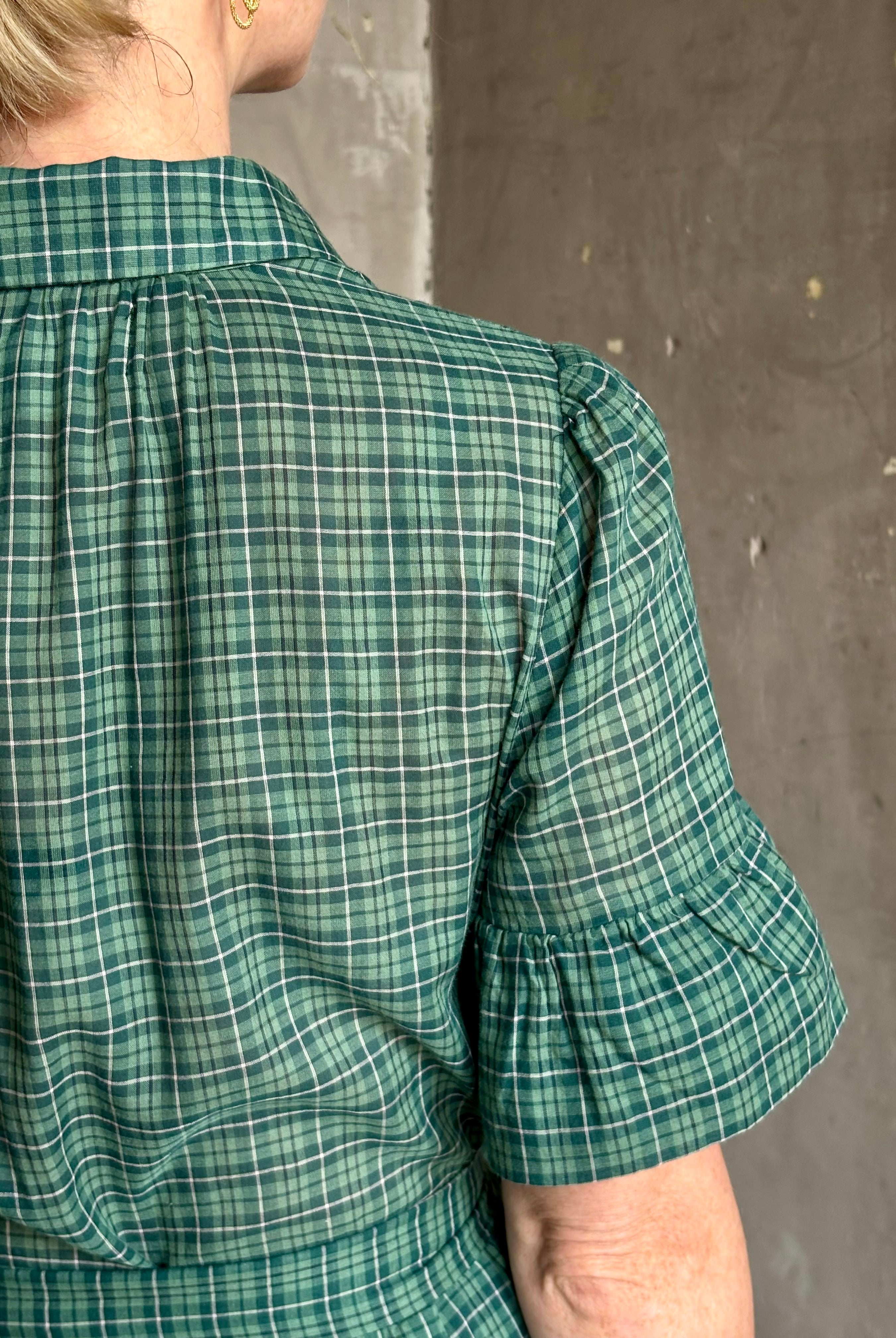 Mature woman wearing Trovata Martine button-up front cotton poplin green plaid maxi dress short sleeves and lightweight