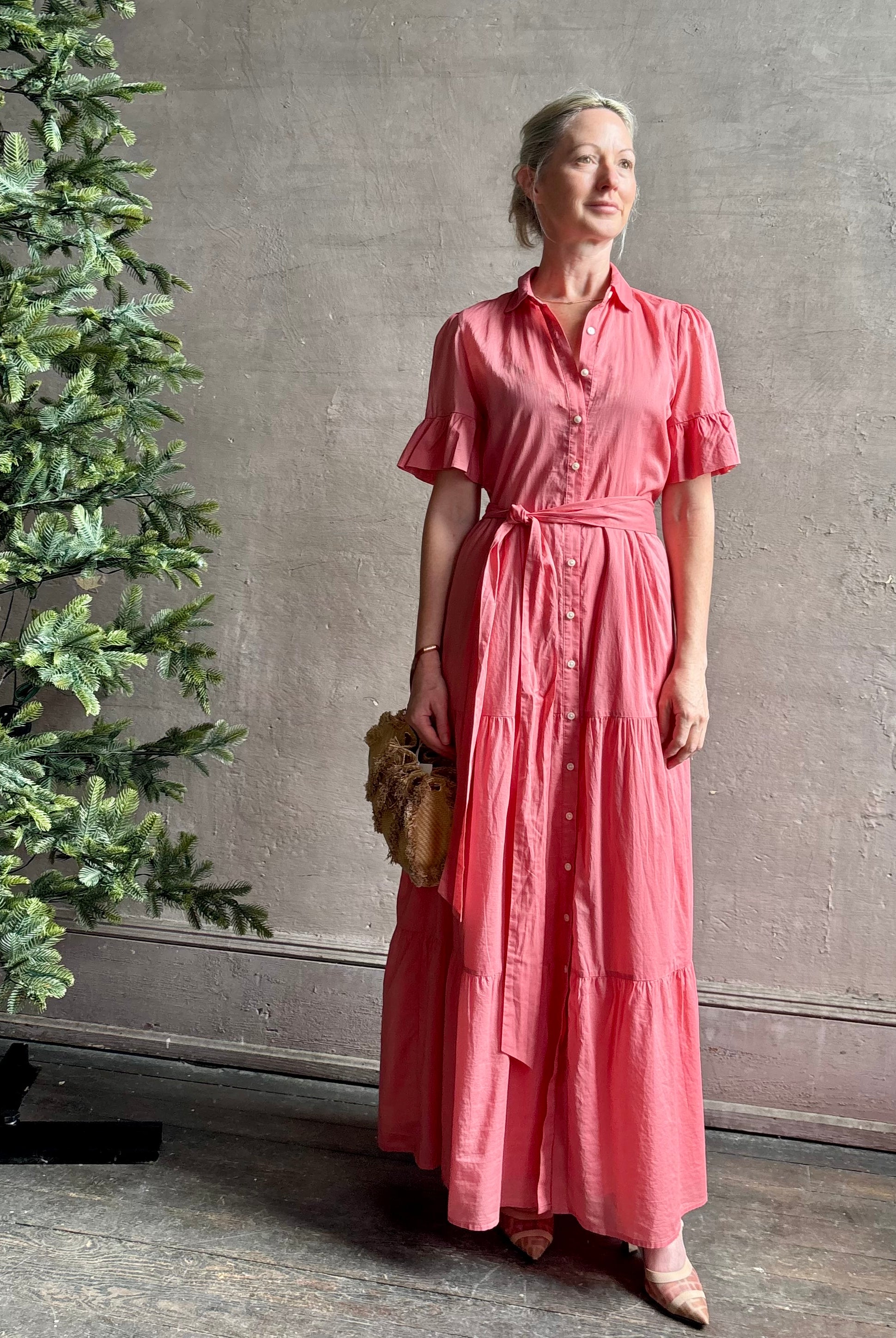 Image of woman wearing TROVATA Martine button down cotton shirt dress in Rosdo rose with feminine ruffle sleeves and tiered skirt