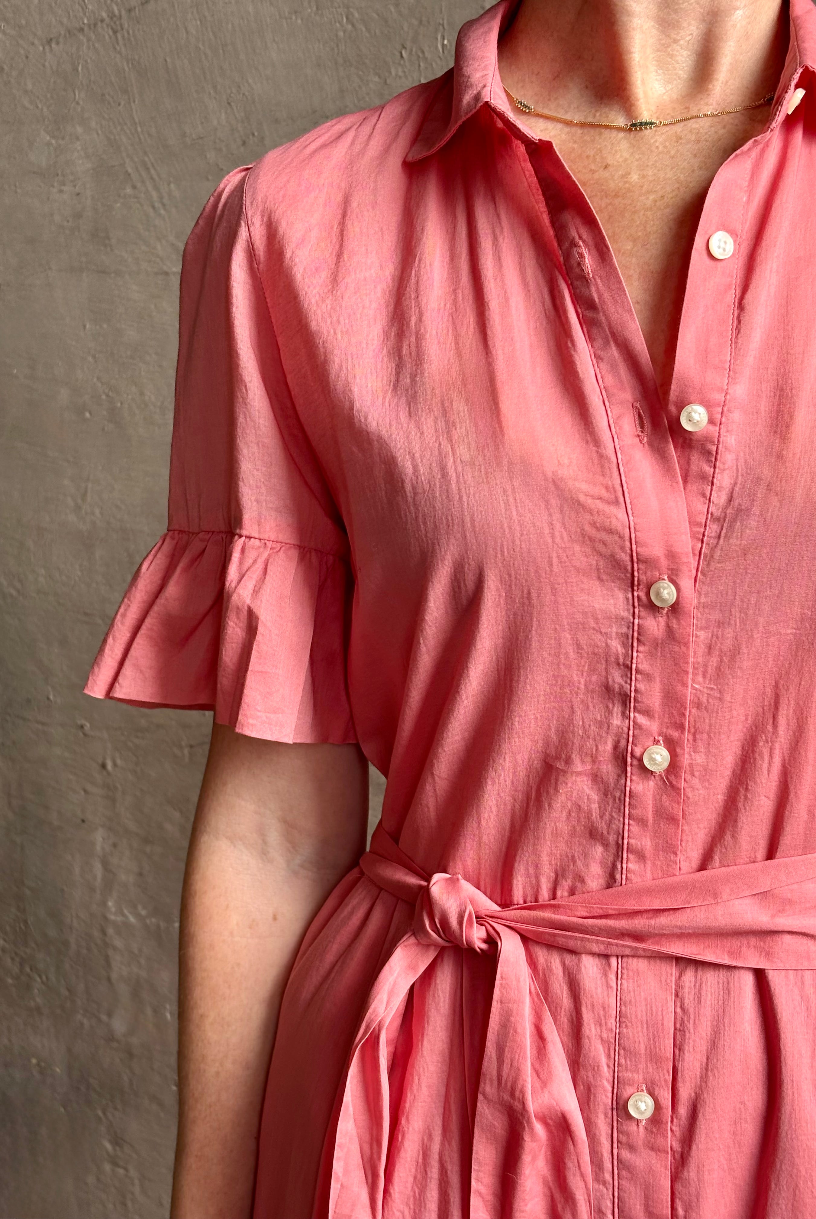 Image of woman wearing TROVATA Martine button down cotton shirt dress in Rosdo rose with feminine ruffle sleeves and tiered skirt