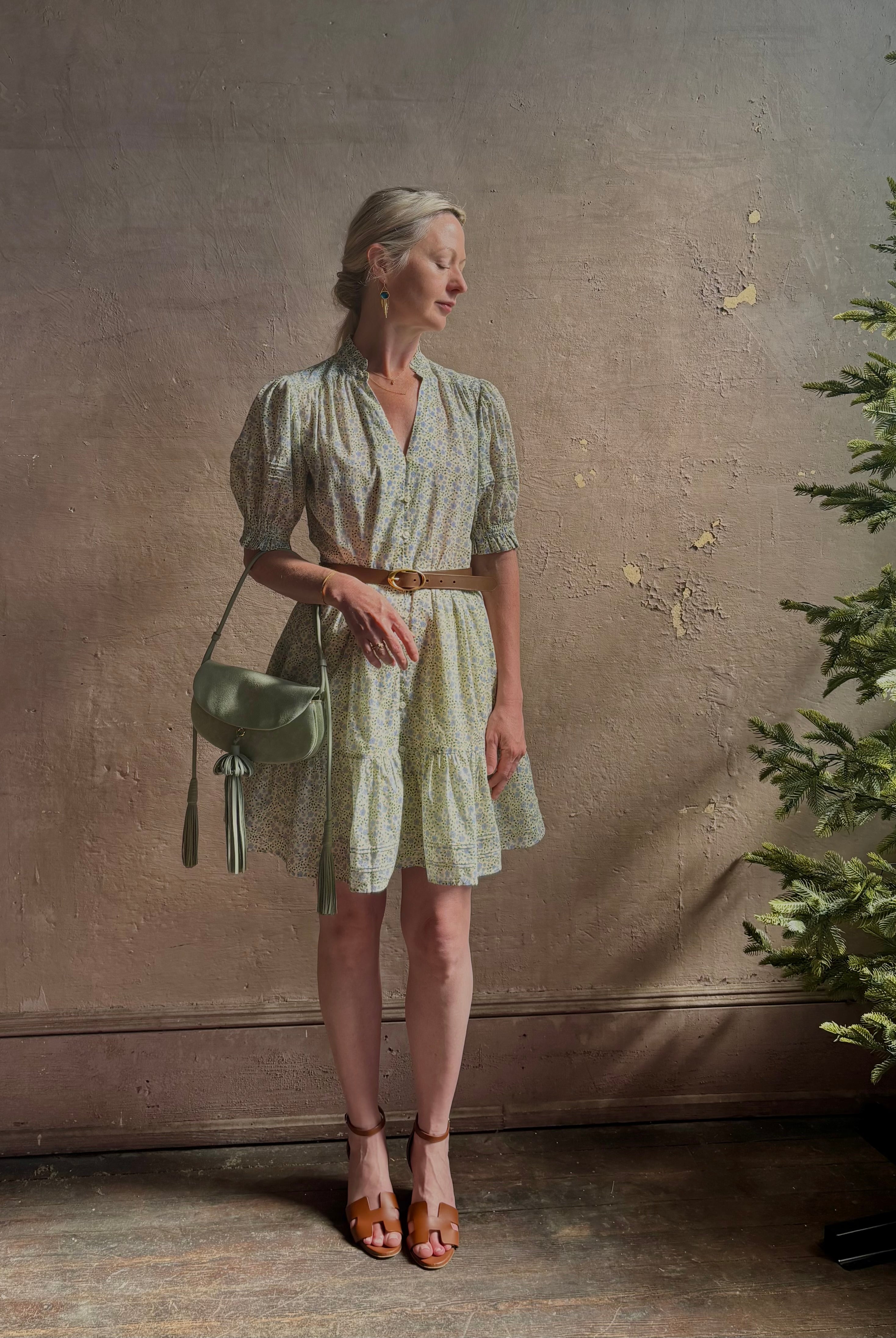 Mature woman wearing the short Phoebe Dress from Trovata rendered in a charming coastal inspired floral print and crafted from cotton with button front, ruffle lined short sleeves and v-neck