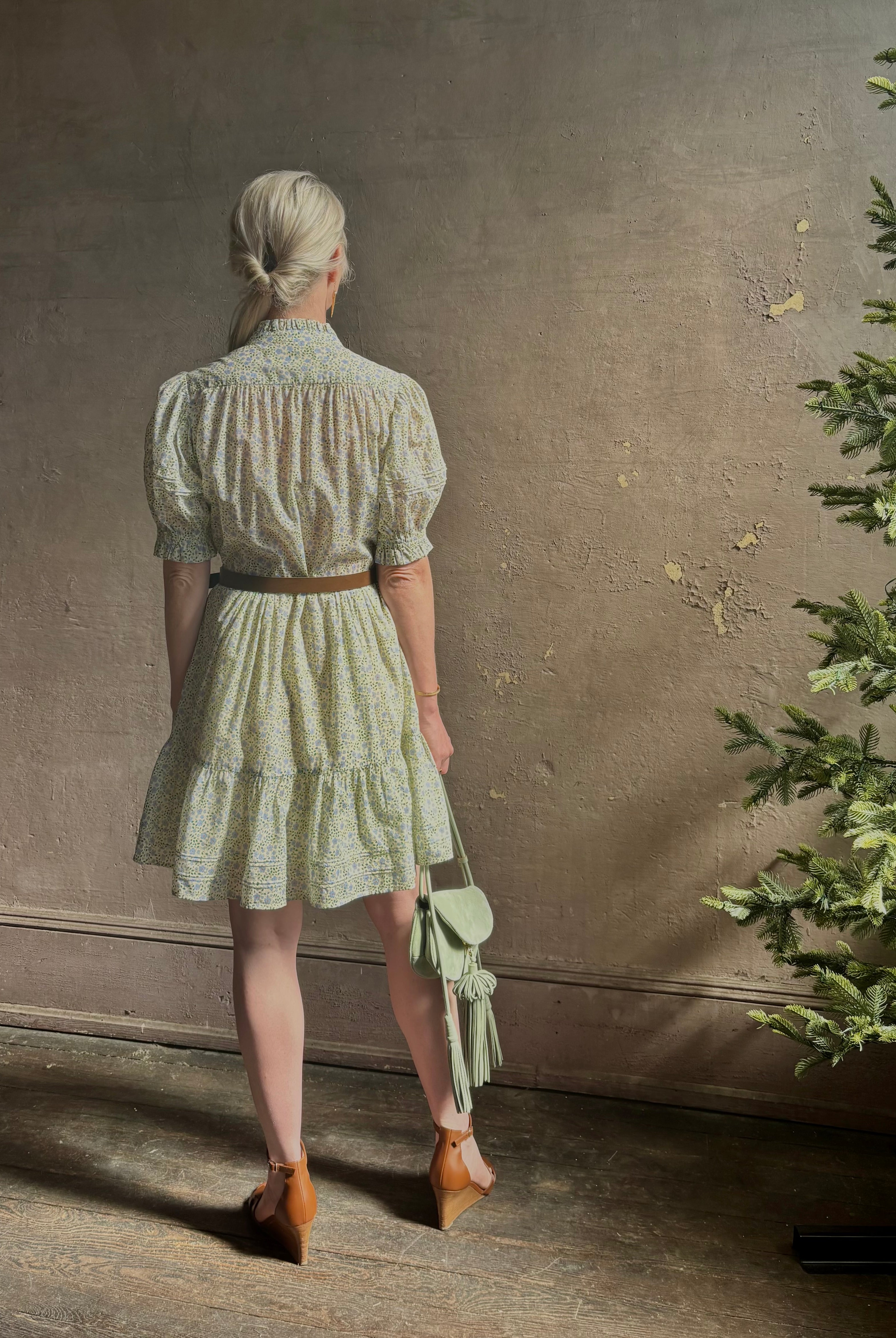 Mature woman wearing the short Phoebe Dress from Trovata rendered in a charming coastal inspired floral print and crafted from cotton with button front, ruffle lined short sleeves and v-neck