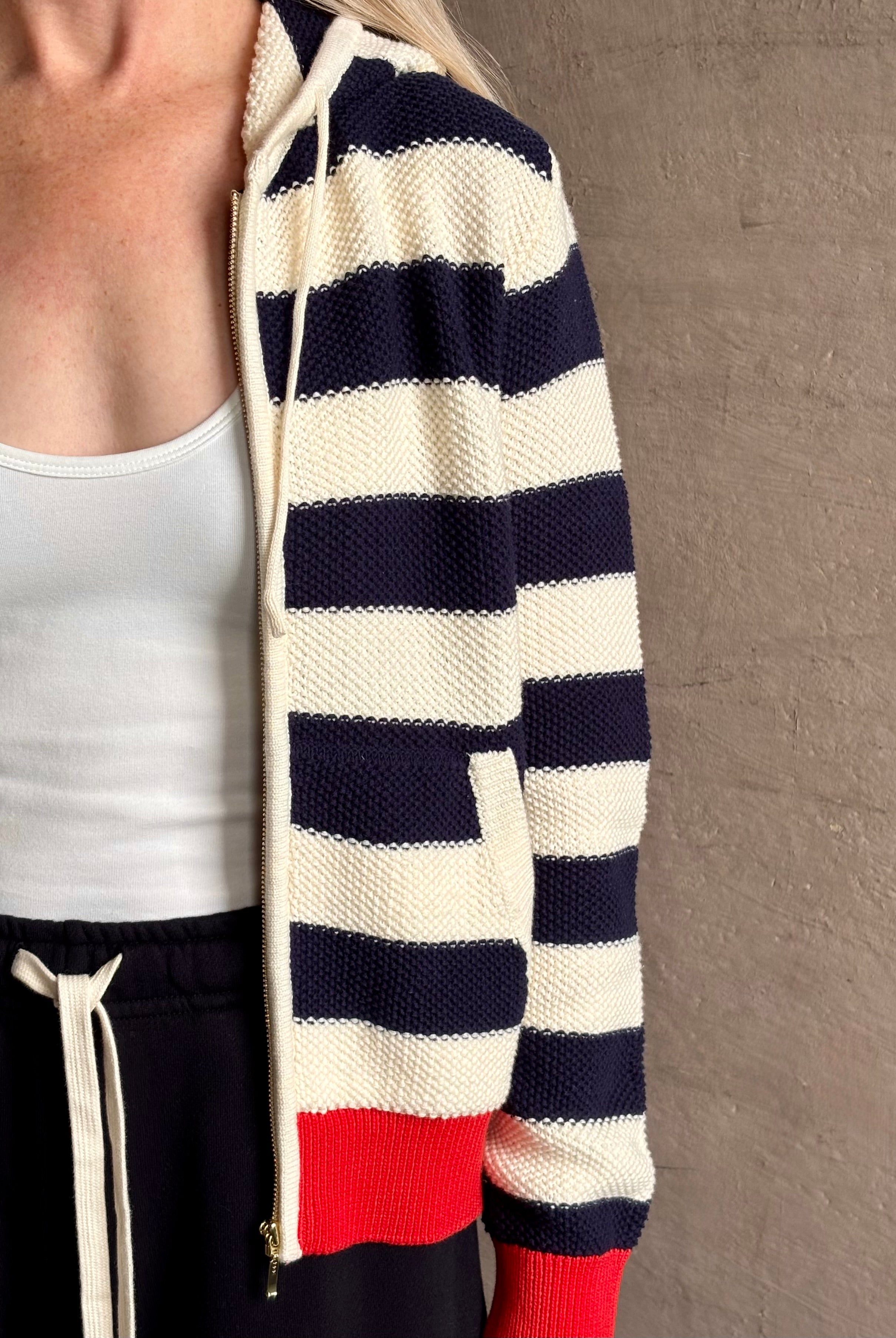 Mature woman wearing comfy cotton Rafa zip up hoodie by Trovata in a classic navy and white stripe with an elevated gold tone zipper.