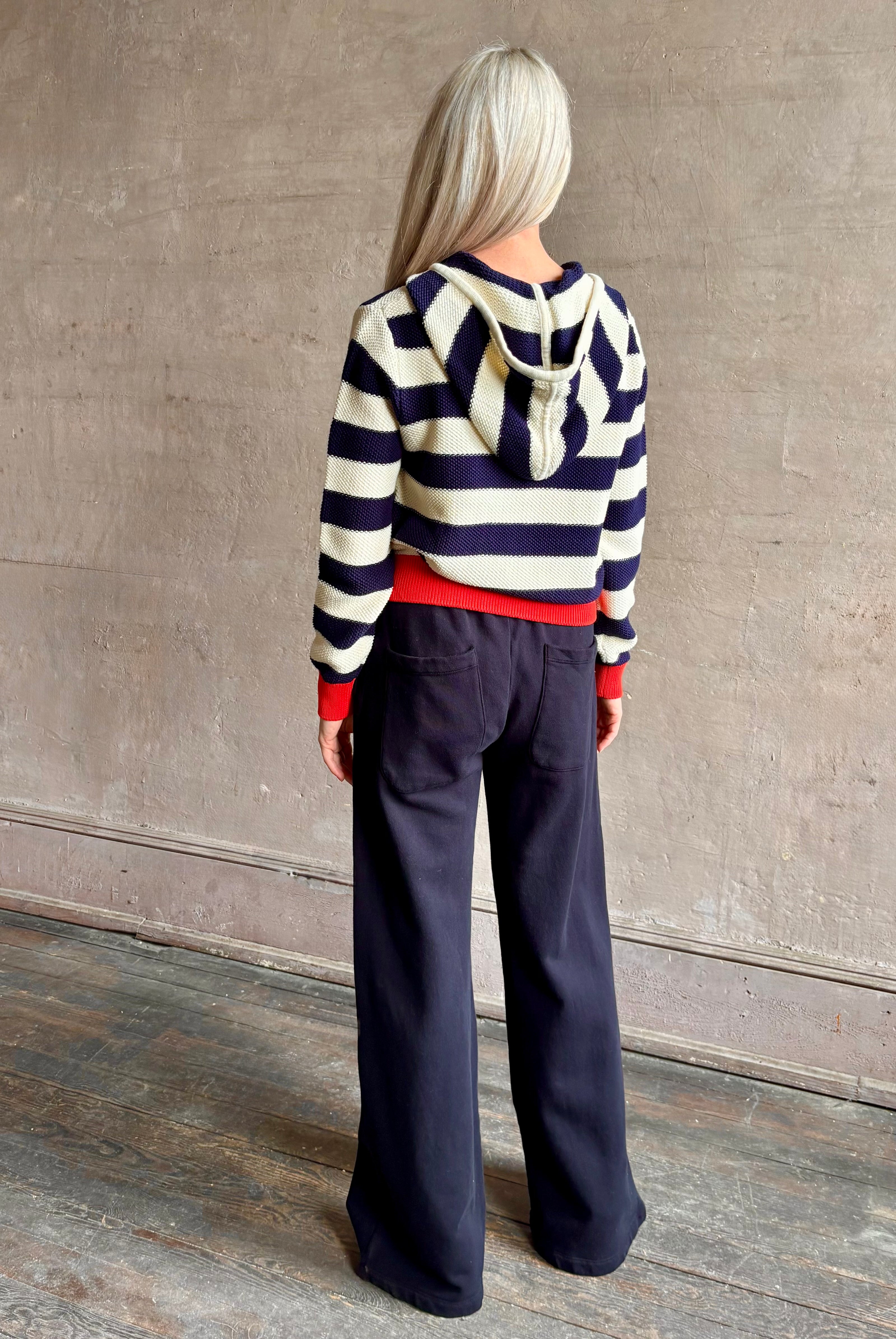 Mature woman wearing comfy cotton Rafa zip up hoodie by Trovata in a classic navy and white stripe with an elevated gold tone zipper.