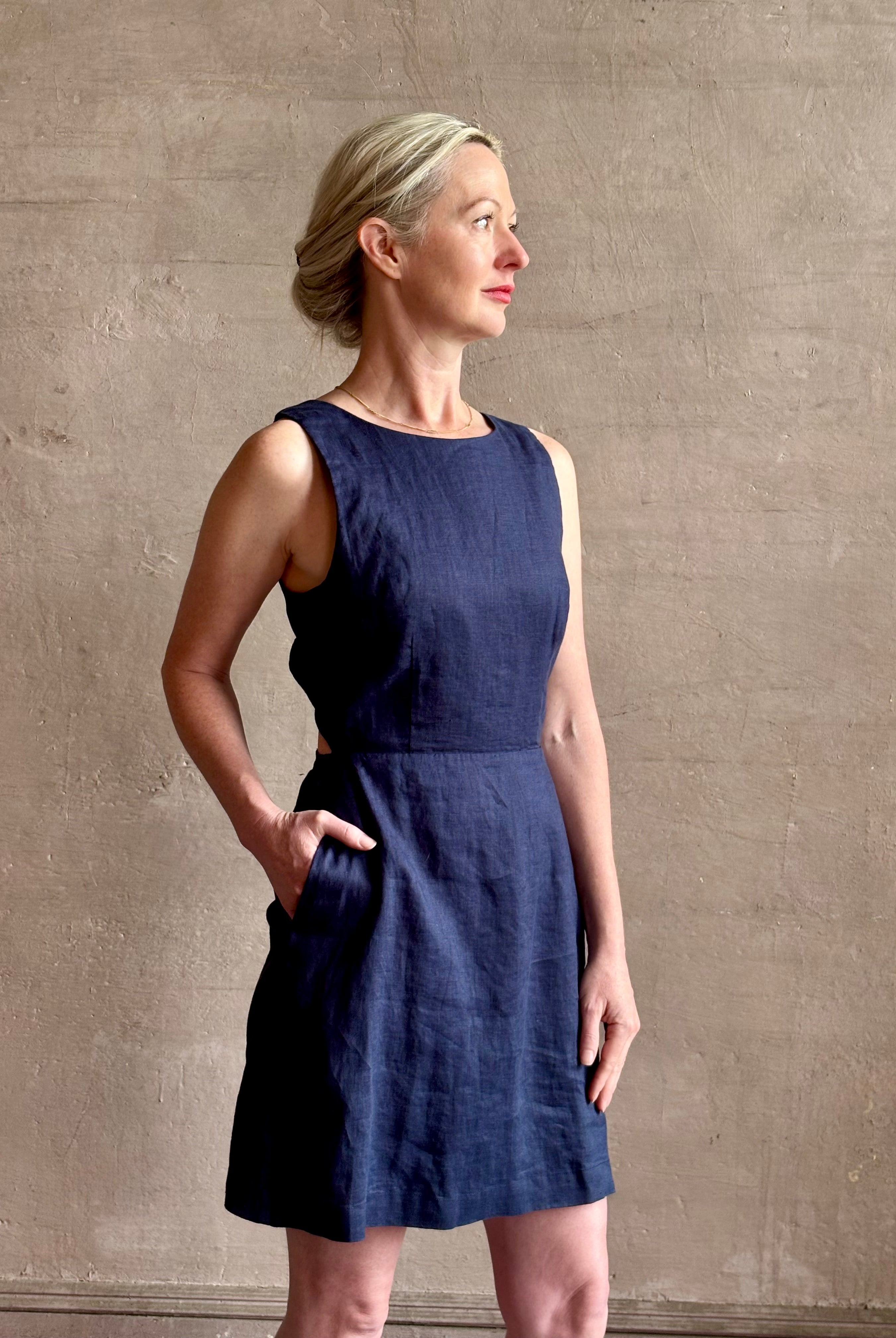 Woman wearing the effortless summer dress by Trovata Rosalie linen Dress in Navy Blue with A-line skirt and sophisticated bra friendly open back