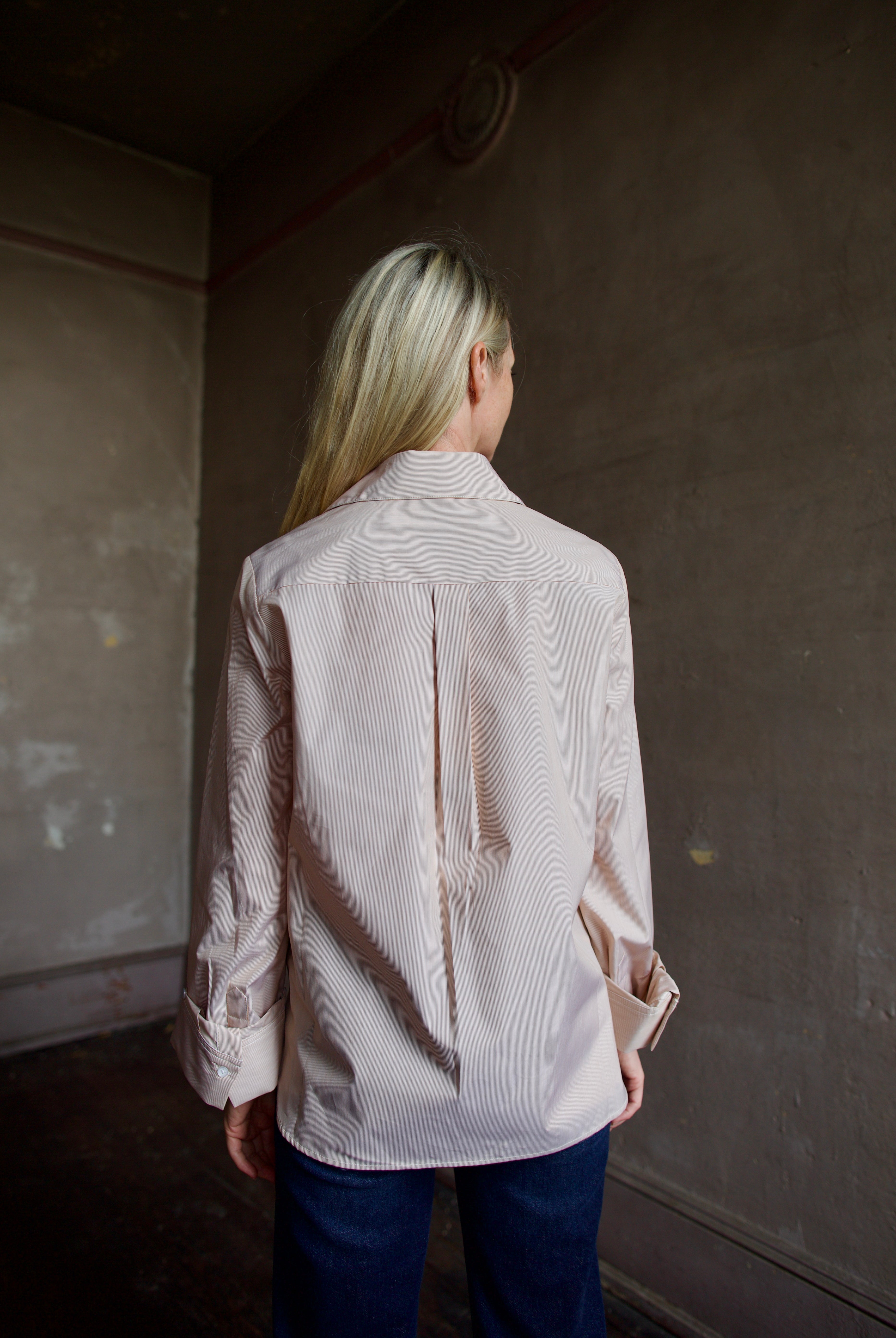 Back of model wearing striped TWP button down boyfriend shirt and denim