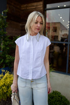 Mature model wearing luxury brand TWP white cap sleeve top with detachable crystal beaded collar in premium cotton