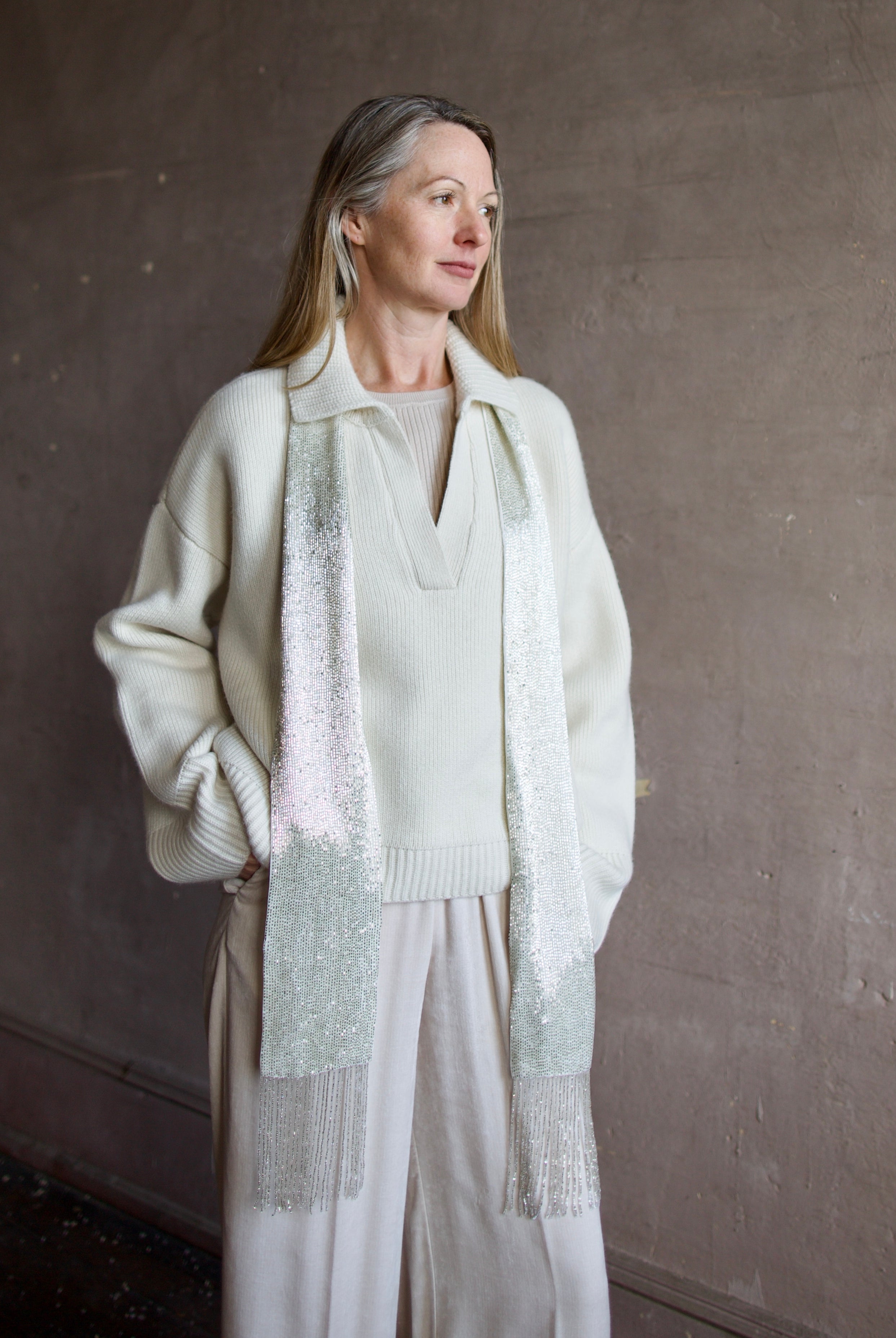 image of a woman wearing the TWP ribbed top and beaded scarf with the Naadam Ultra Luxe Pullover