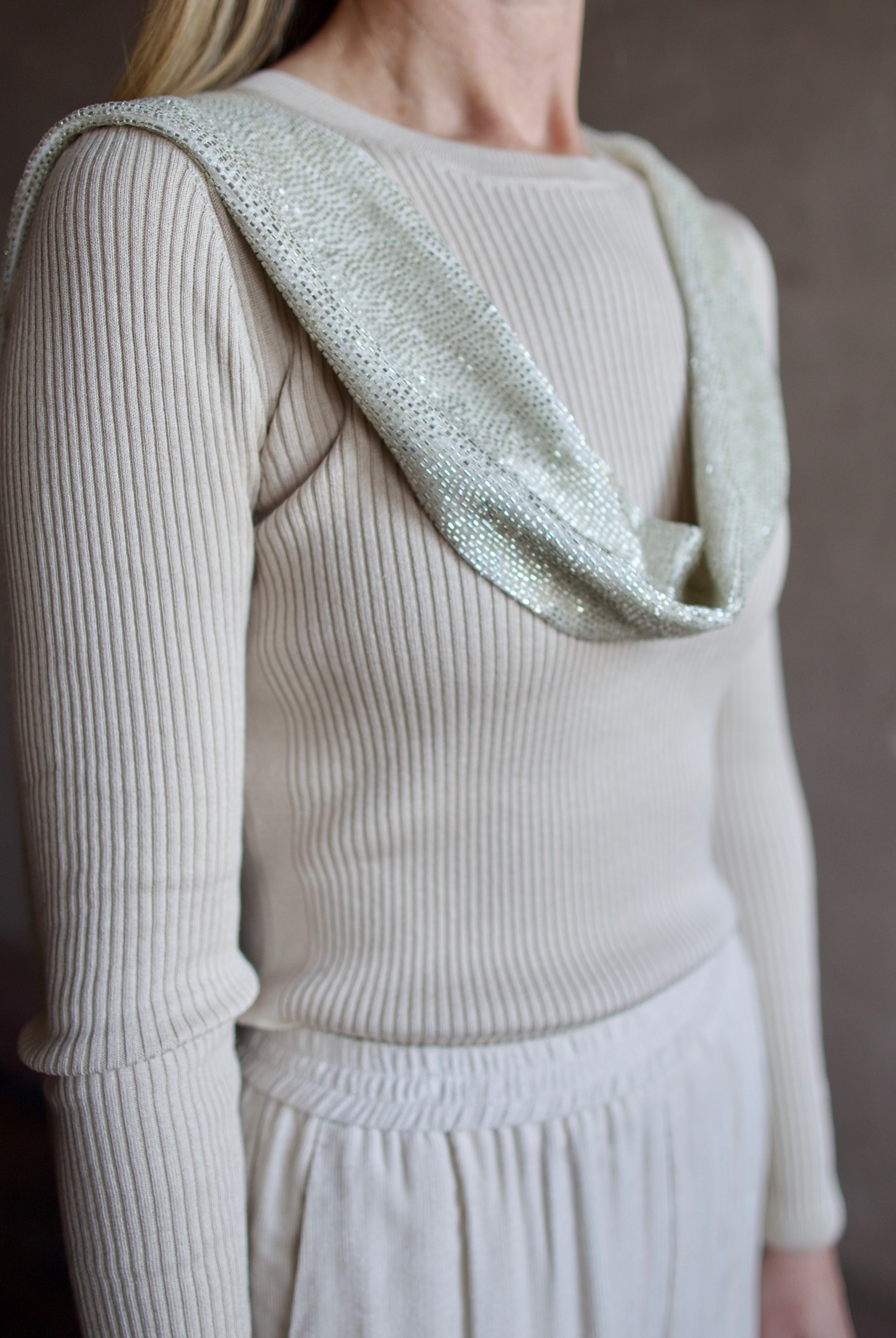 close up image of a woman wearing the TWP ribbed top and beaded scarf