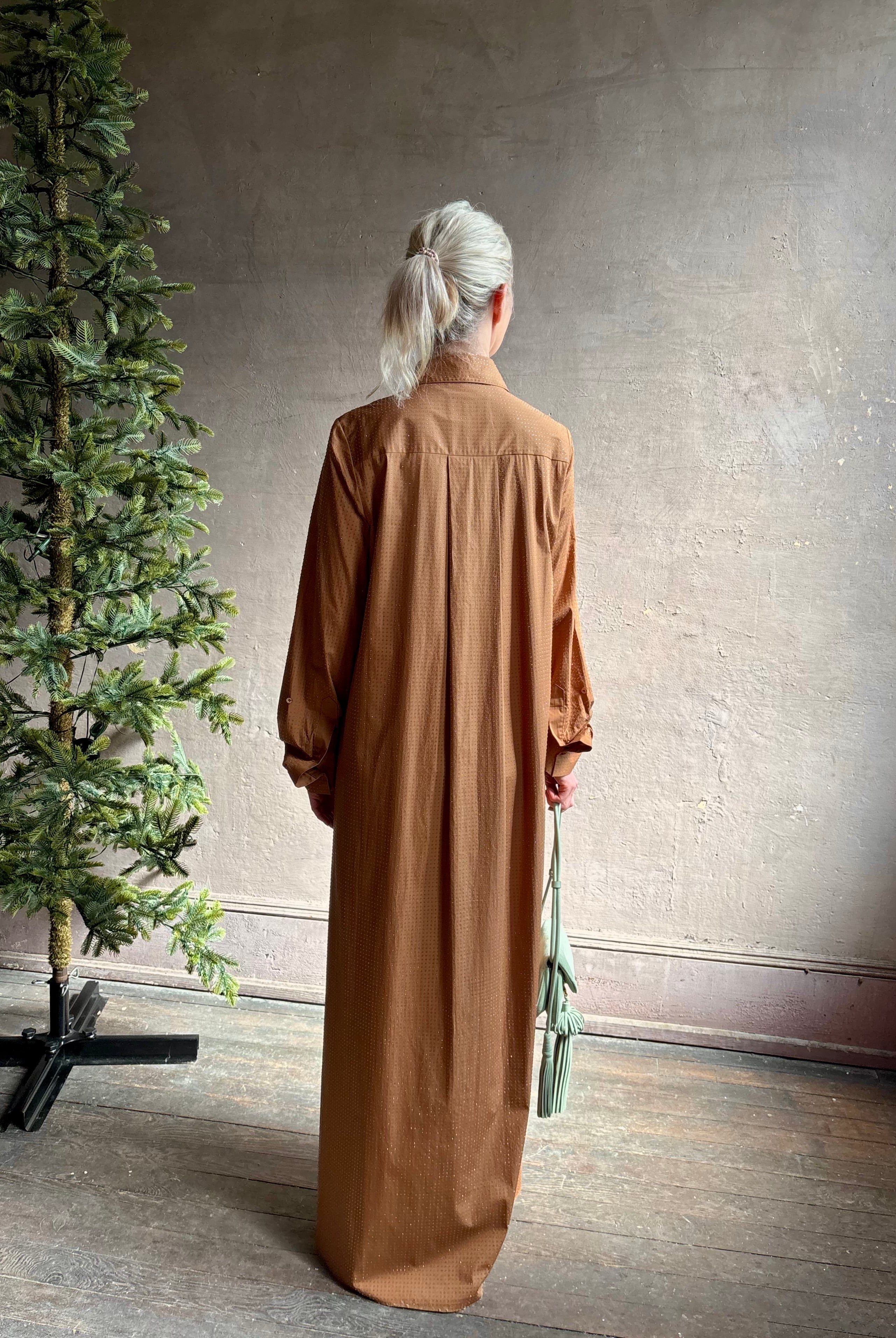 Mature woman wearing sophisticated TWP Jennys shirt dress embellished with crystals in warm brown