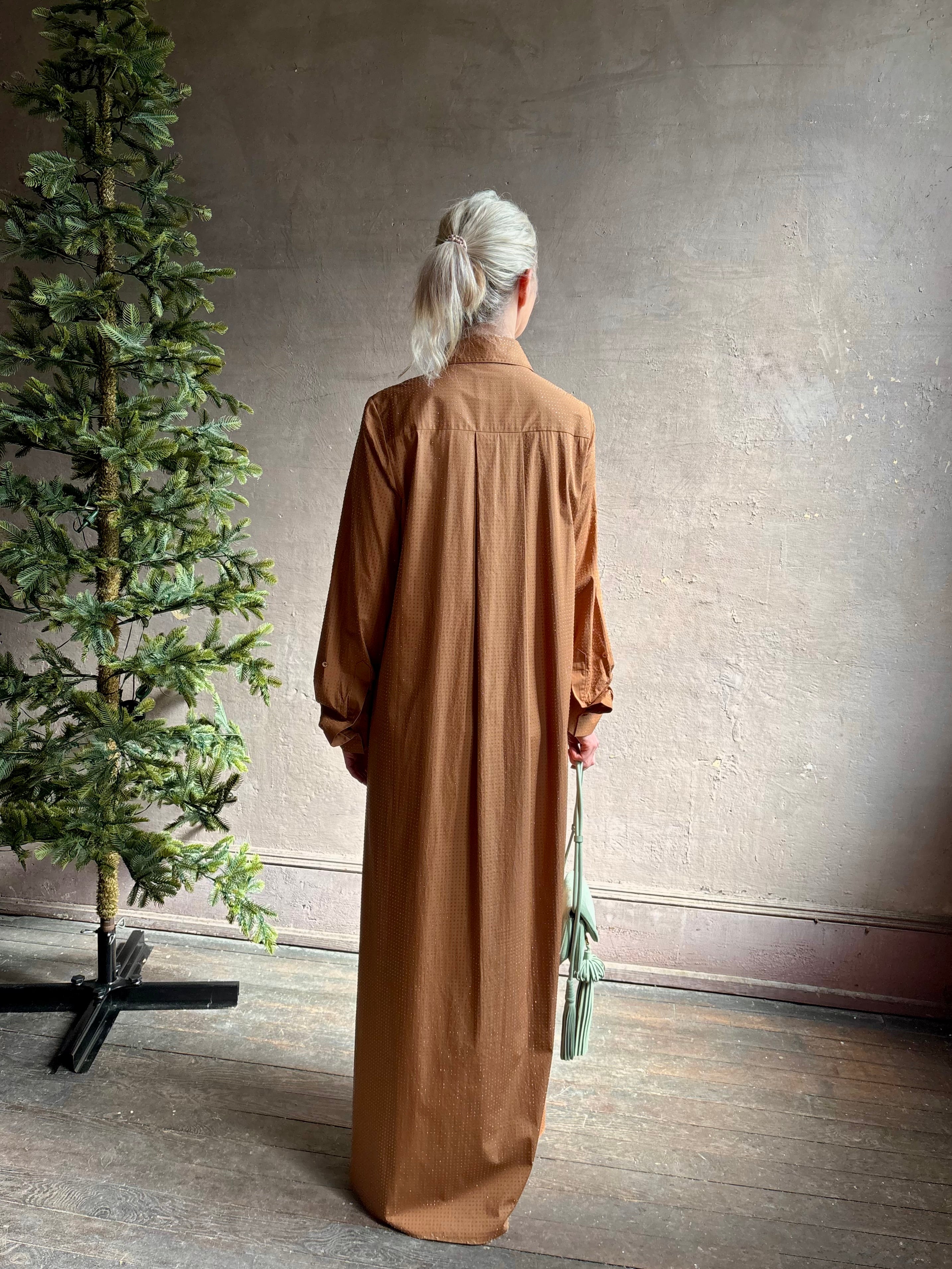 Mature woman wearing sophisticated TWP Jennys shirt dress embellished with crystals in warm brown