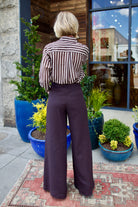 Image of model wearing luxury brand TWP Joey Striped blouse and Dees chocolate linen Trousers expertly tailored timeless elegance
