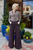 Image of model wearing luxury brand TWP Joey Striped Top and expertly tailored Dees chocolate linen Trousers
