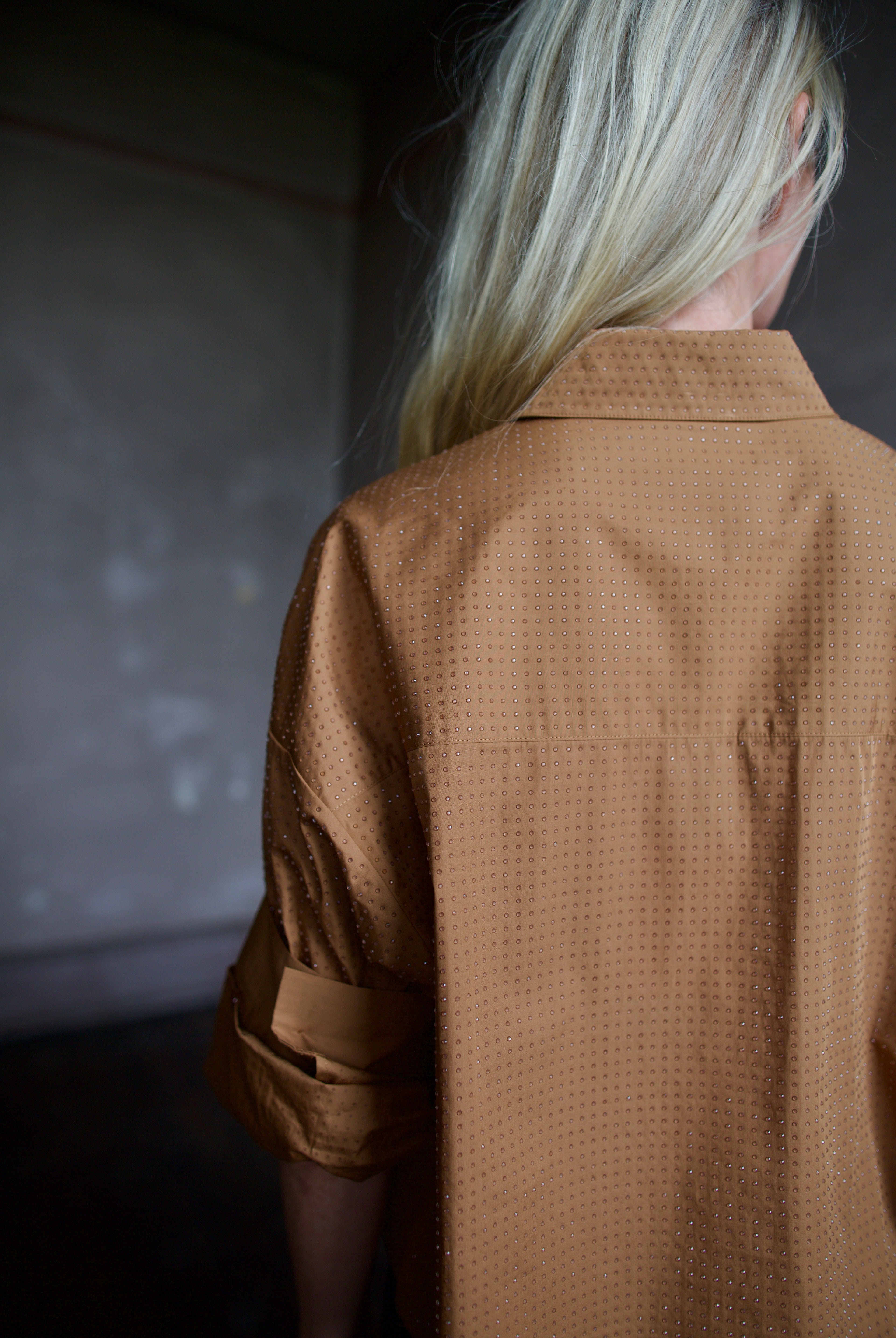 Close up detail of model wearing a TWP shirt embellished with crystals in a warm brown