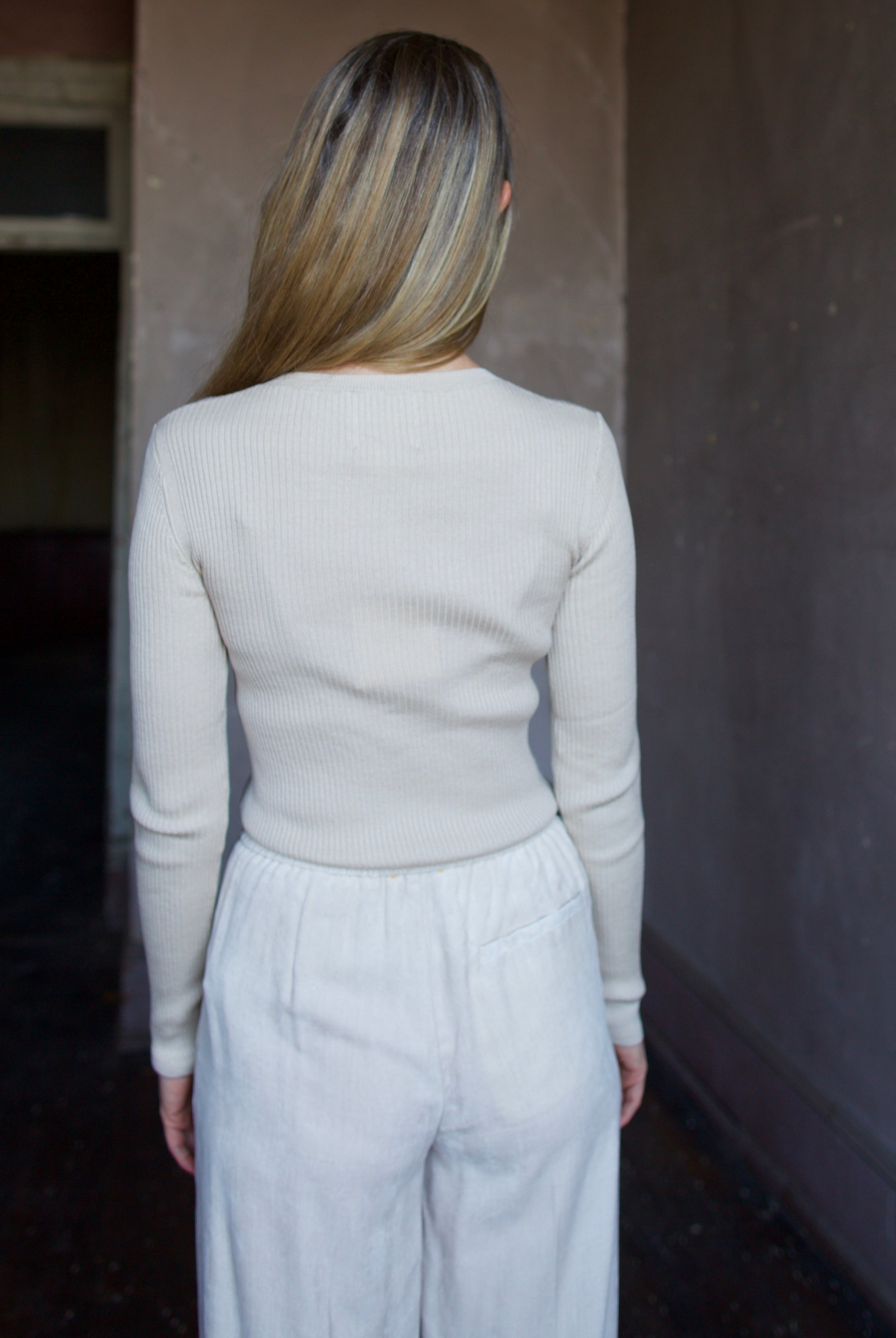 Image of mature woman wearing TWP Secondskin top in Wheat showcases luxurious comfort through 100% wool construction and distinctive ribbed texture