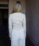 Image of mature woman wearing TWP Secondskin top in Wheat showcases luxurious comfort through 100% wool construction and distinctive ribbed texture