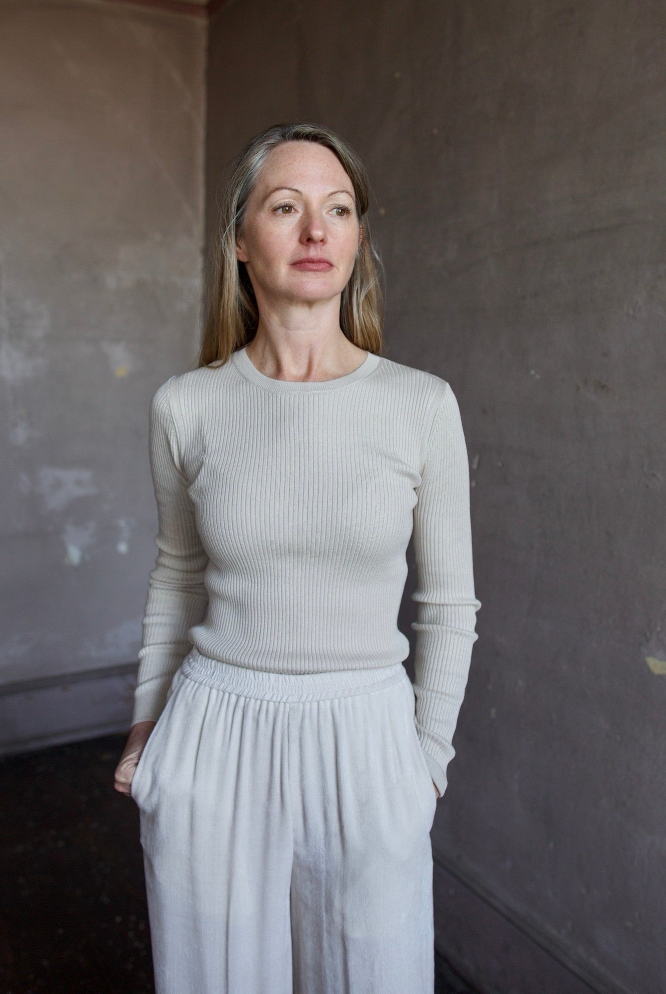 Image of mature woman wearing TWP Secondskin top in Wheat showcases luxurious comfort through 100% wool construction and distinctive ribbed texture