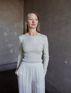 Image of mature woman wearing TWP Secondskin top in Wheat showcases luxurious comfort through 100% wool construction and distinctive ribbed texture