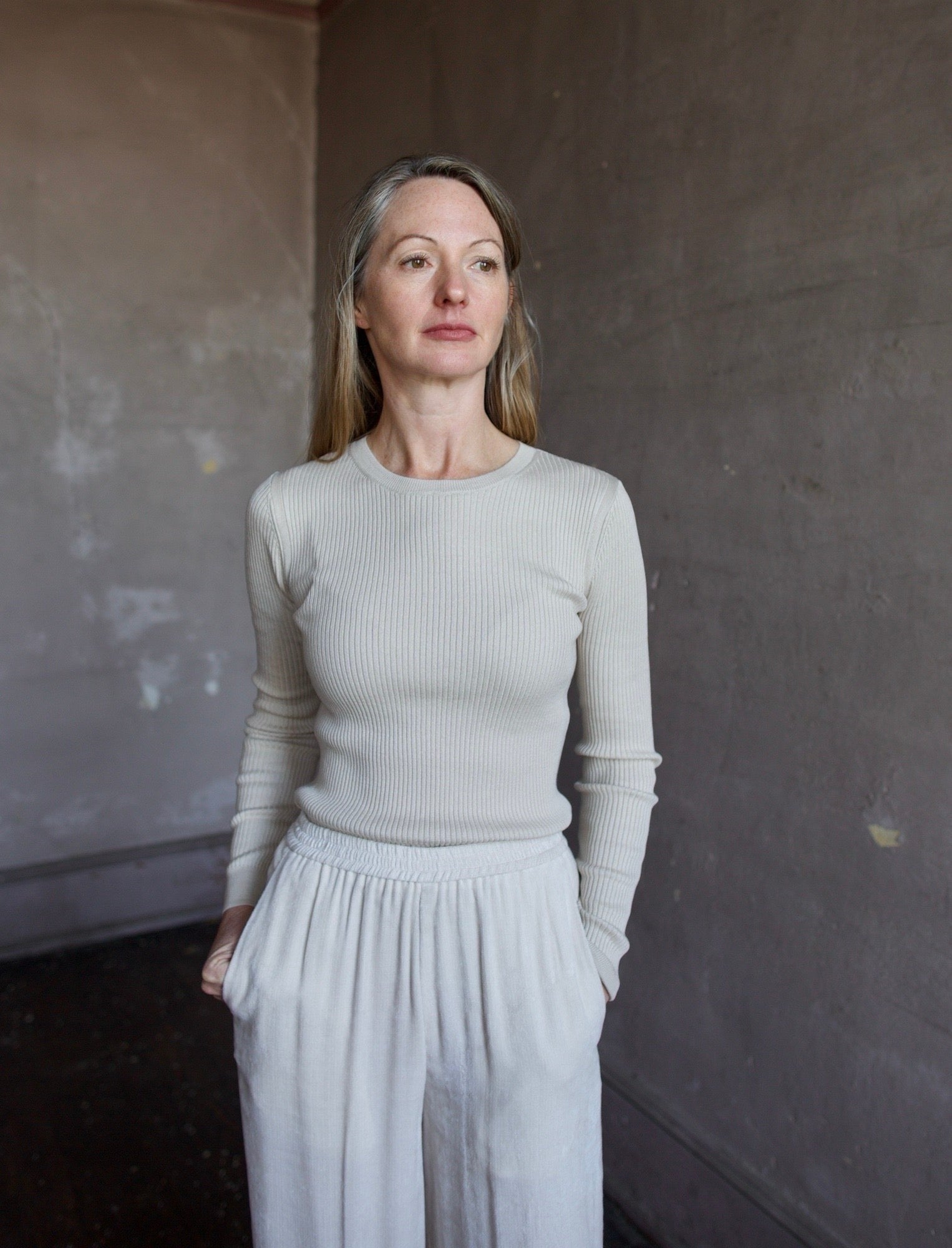 Image of mature woman wearing TWP Secondskin top in Wheat showcases luxurious comfort through 100% wool construction and distinctive ribbed texture