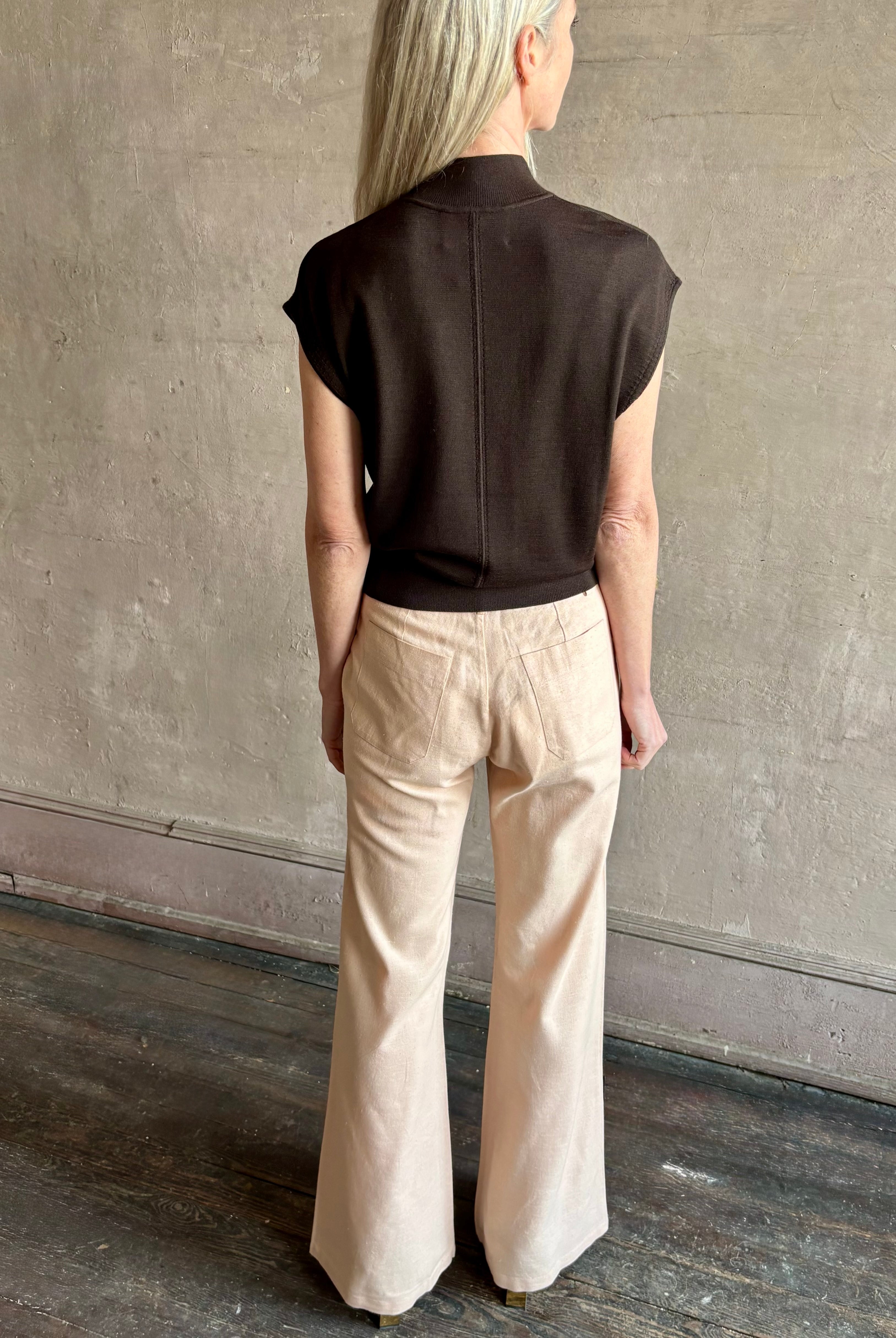 Woman wearing TWP Chocolate brown Wren Sweater in Premium Merino Wool Knitwear with mock neck and cap