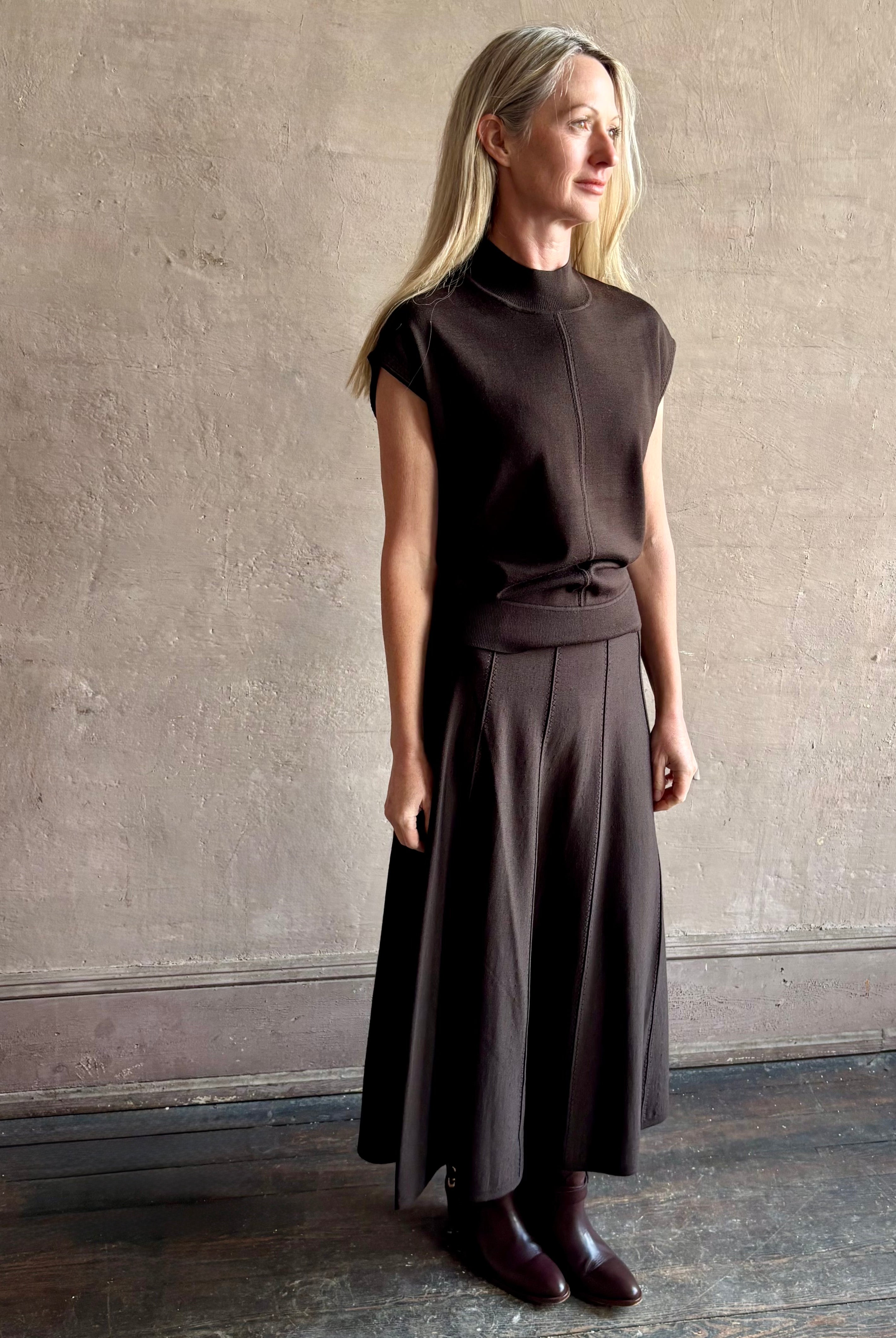 Woman wearing TWP Chocolate brown Wren Sweater and matching skirt set in Premium Merino Wool Knitwear