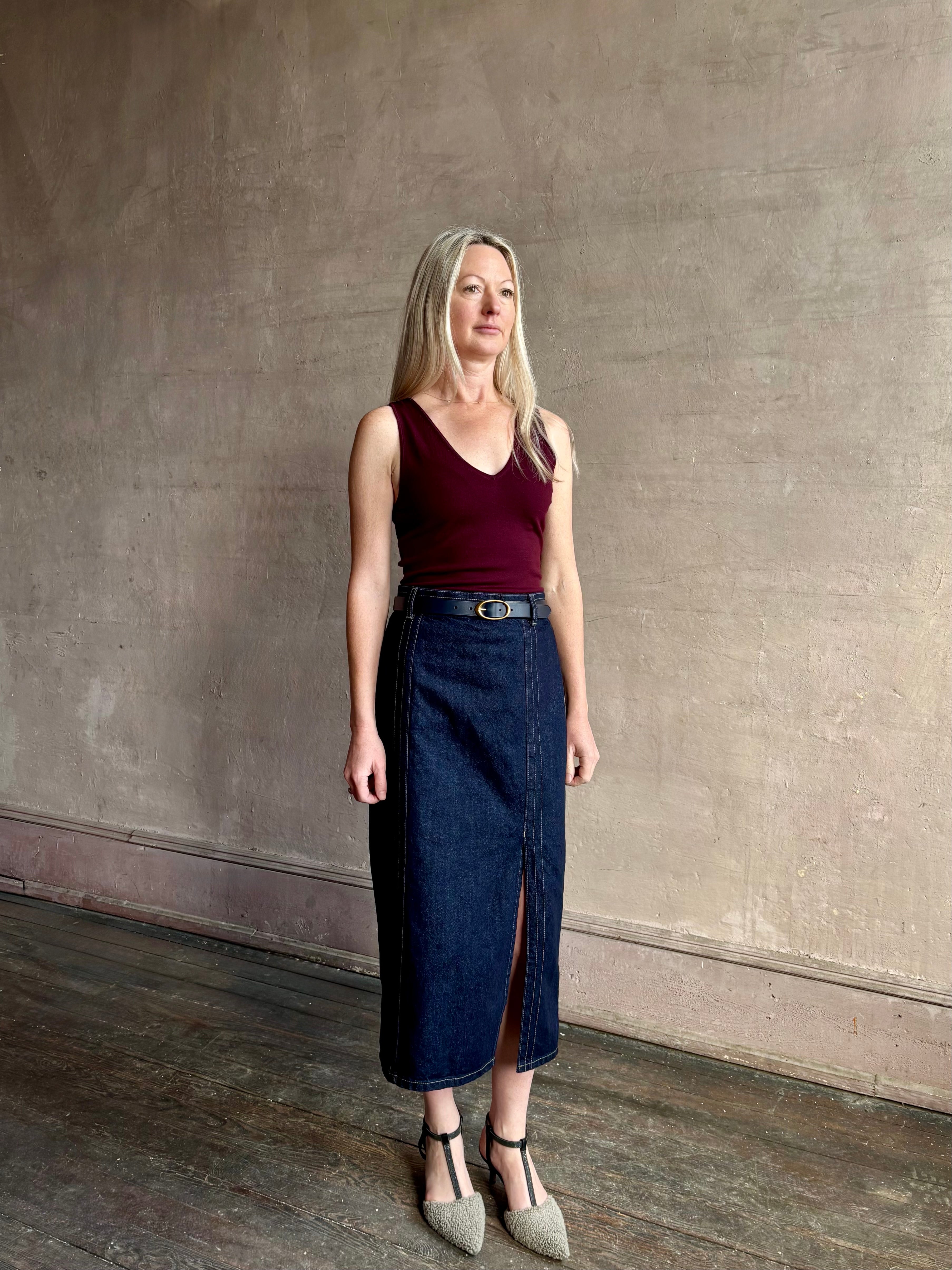 Image of mature woman wearing Premium Cotton American-Made Denim maxi skirt by TWP with Seams and front vent in Dark Stone wash