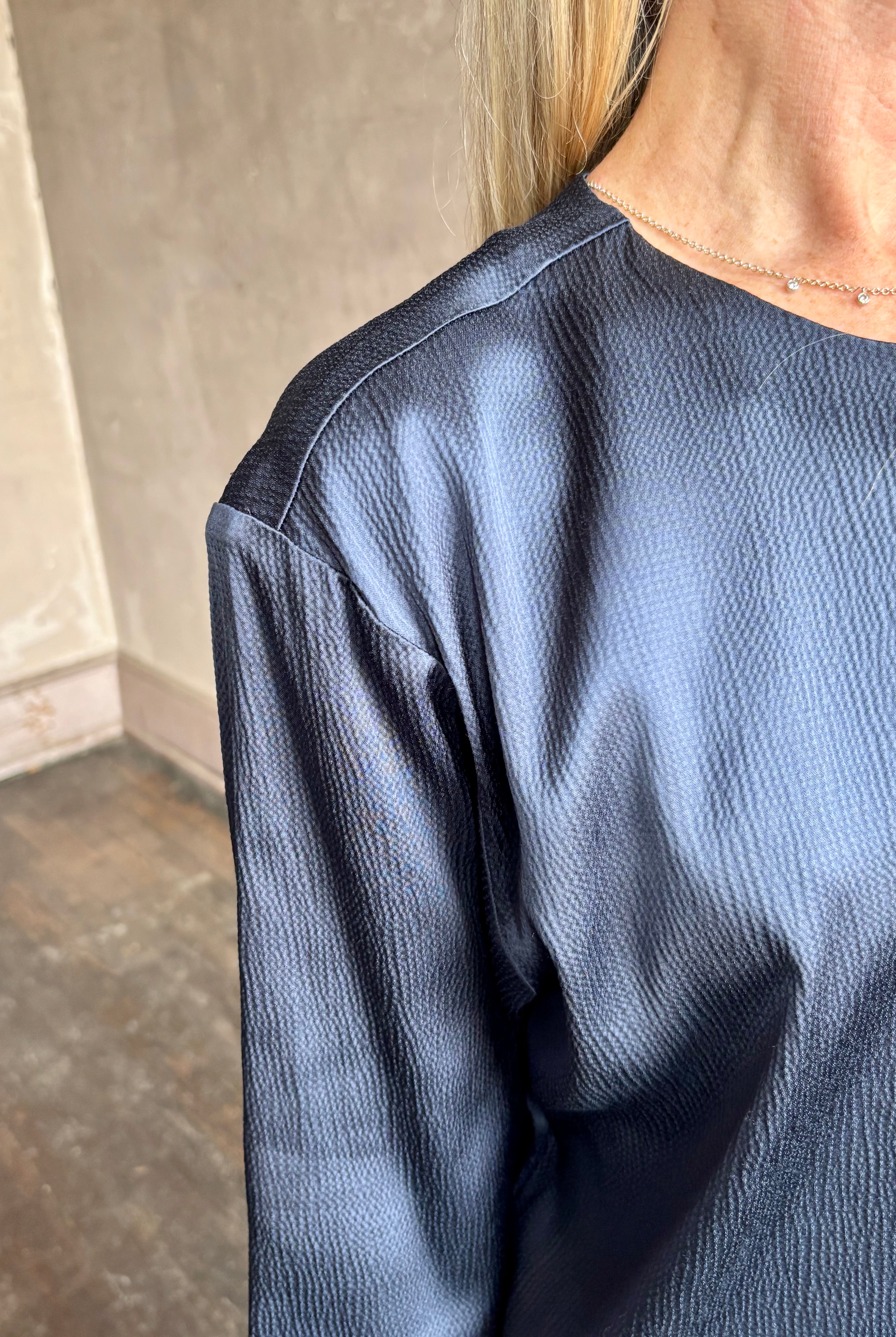 Image of mature woman wearing TWP Ex T in premium hammered satin with short sleeve crew neck and a casual front pocket