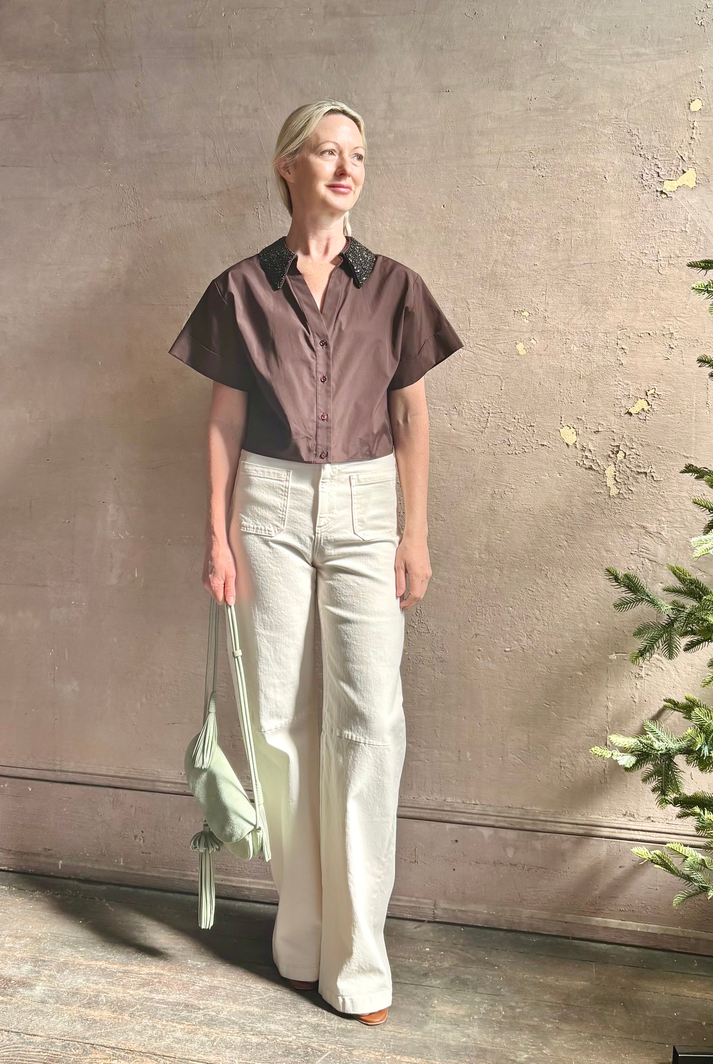 Mature woman wearing Forever and Always with Crystal Collar Top from TWP women's luxury designer blouse rendered in chocolate brown and crafted from 100% cotton in the USA with crystal collar, short sleeves and reversible