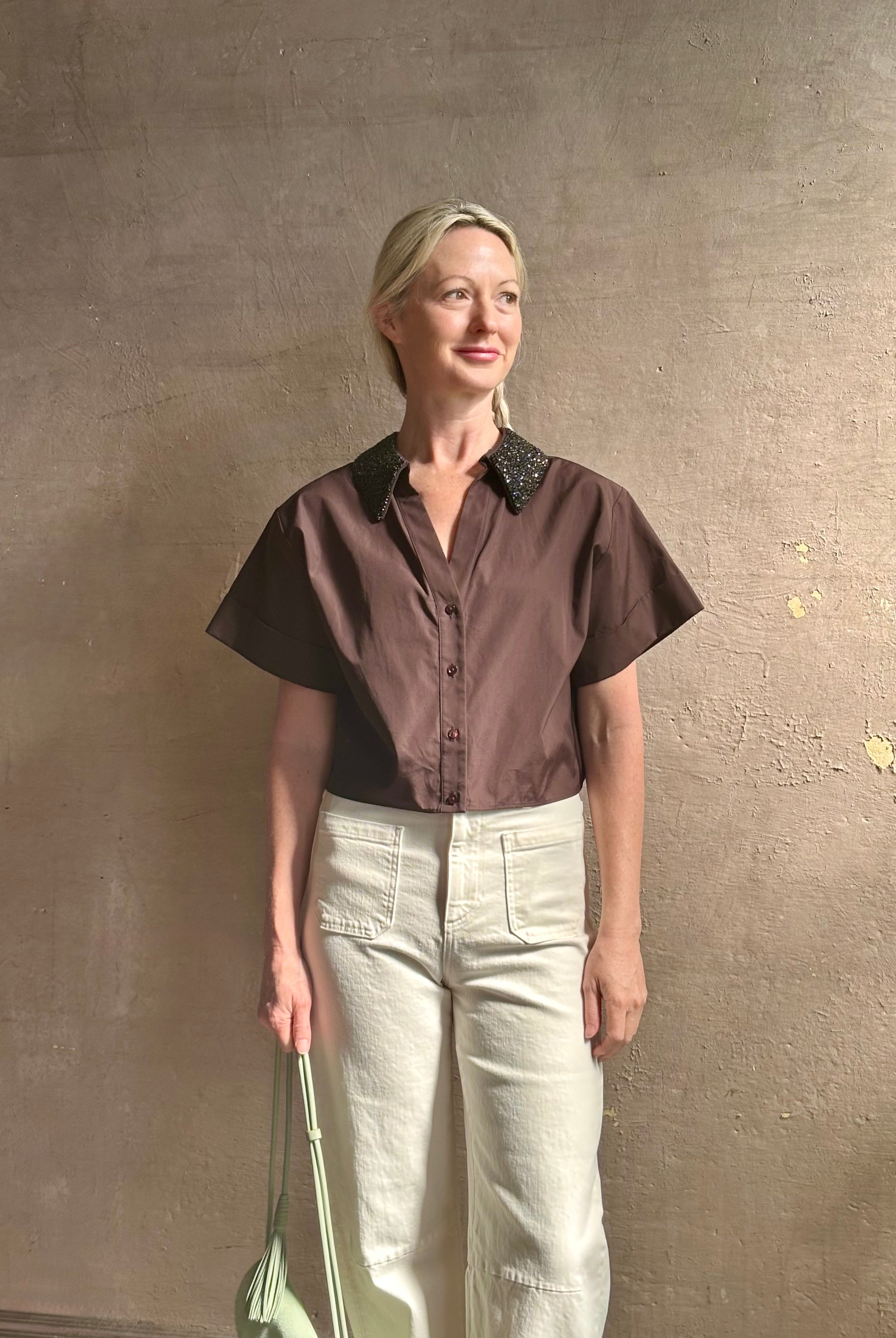 Mature woman wearing Forever and Always with Crystal Collar Top from TWP women's luxury designer blouse rendered in chocolate brown and crafted from 100% cotton in the USA with crystal collar, short sleeves and reversible