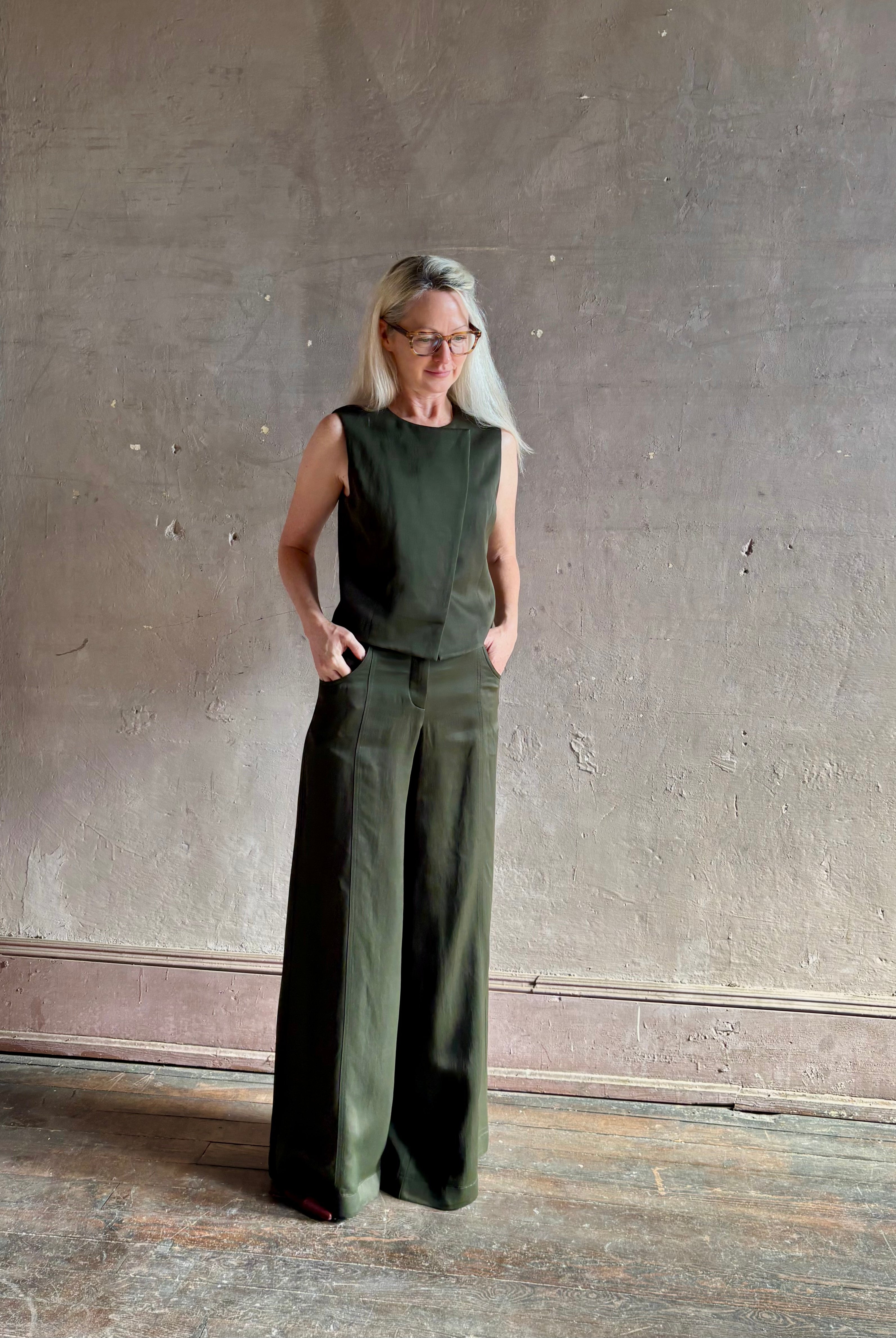Luxury women's clothing brand TWP high neck hidden placket vest top with matching pant set in a green linen blend