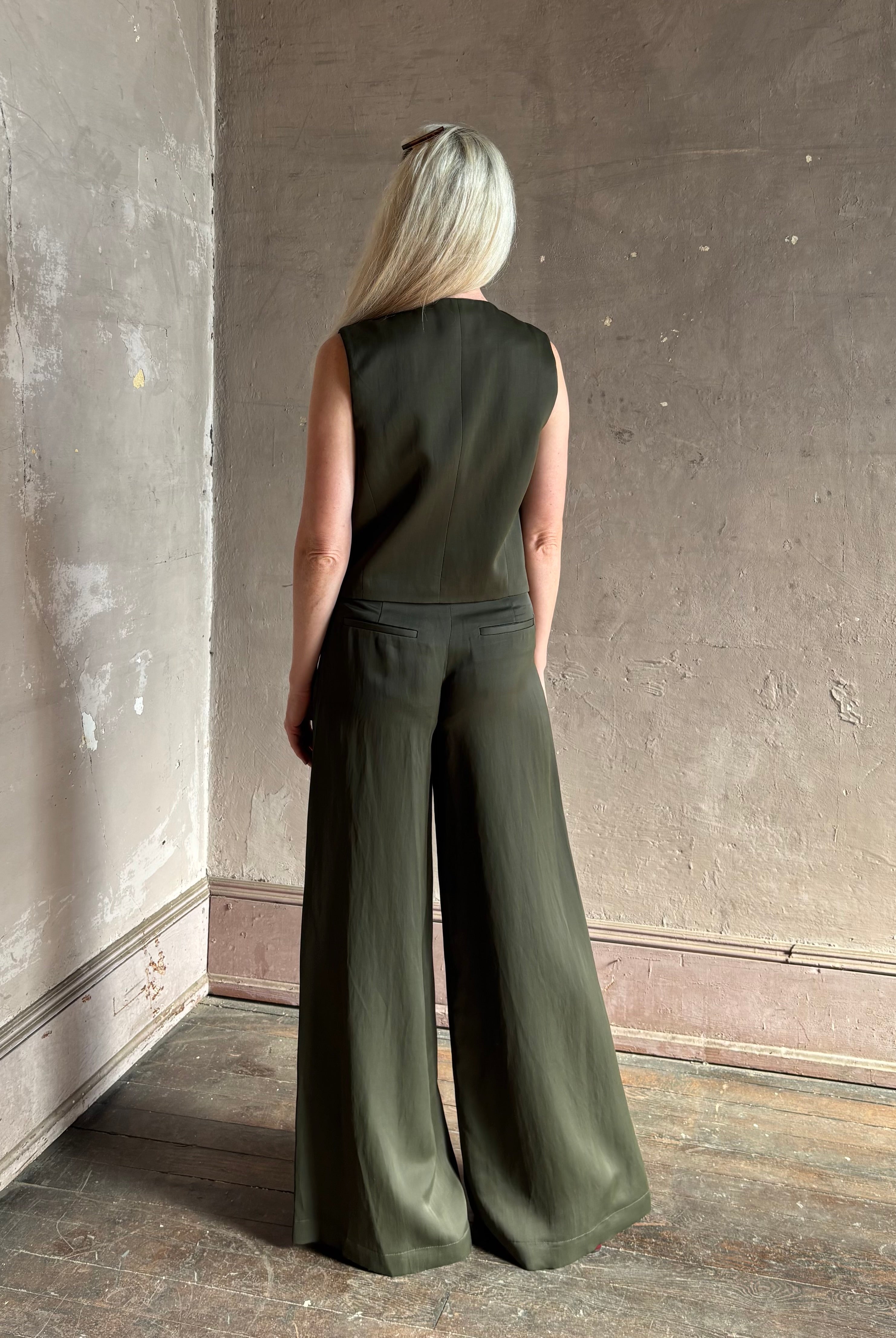 Luxury women's clothing brand TWP high neck hidden placket vest top with matching pant set in a green linen blend