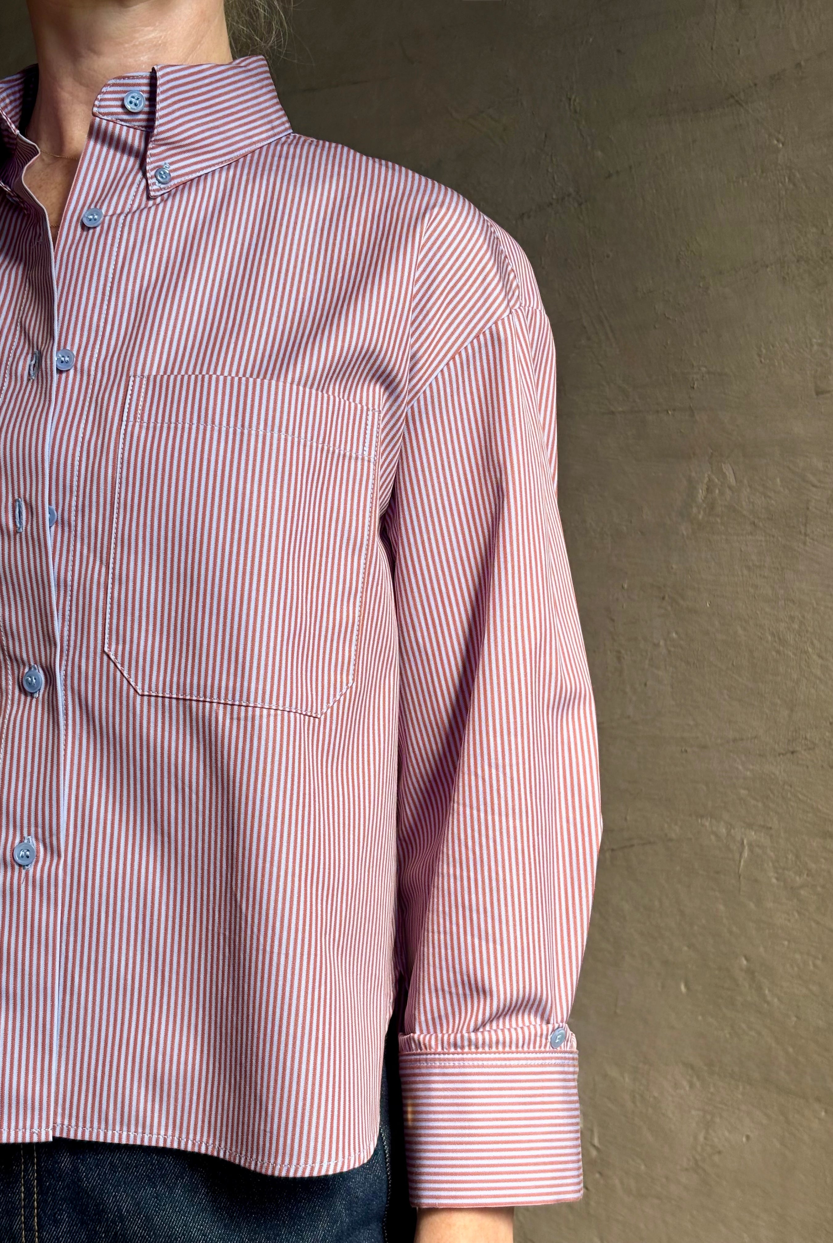 Woman wearing premium cotton poplin JD menswear inspired shirt from TWP rust and blue stripe with long sleeve