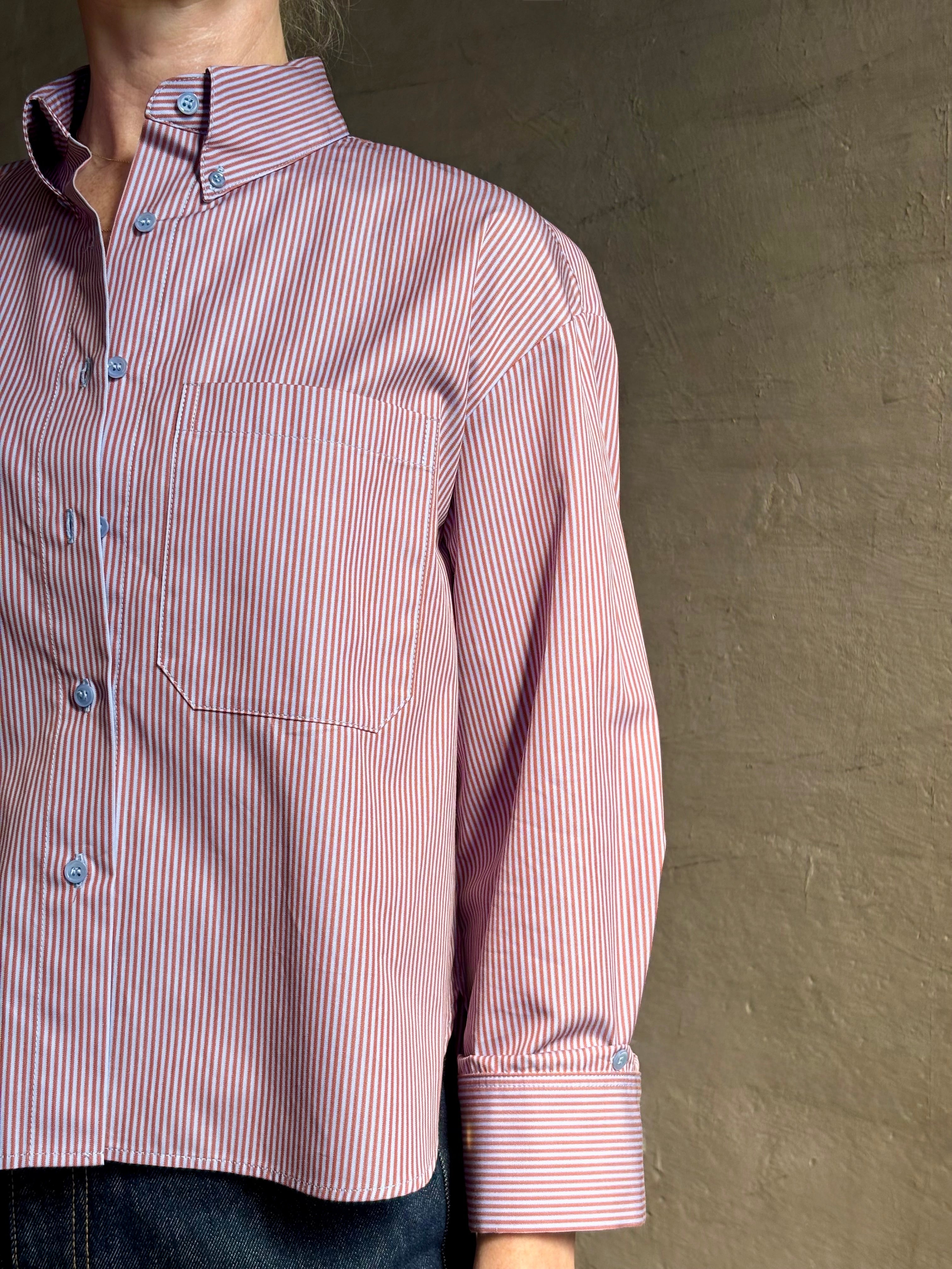 Woman wearing premium cotton poplin JD menswear inspired shirt from TWP rust and blue stripe with long sleeve