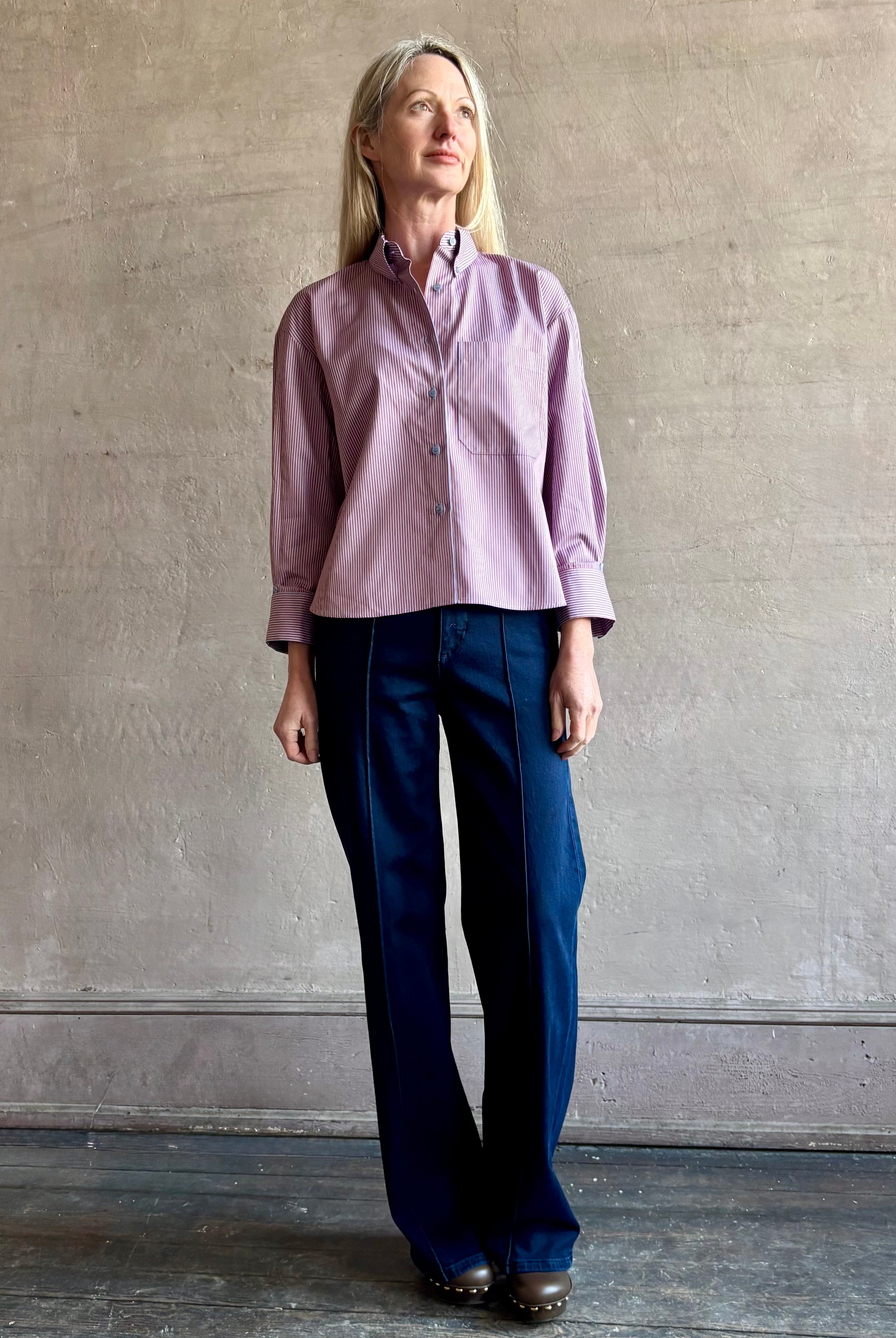 Woman wearing premium cotton poplin JD menswear inspired shirt from TWP in a rust and blue stripe with long sleeve and collar