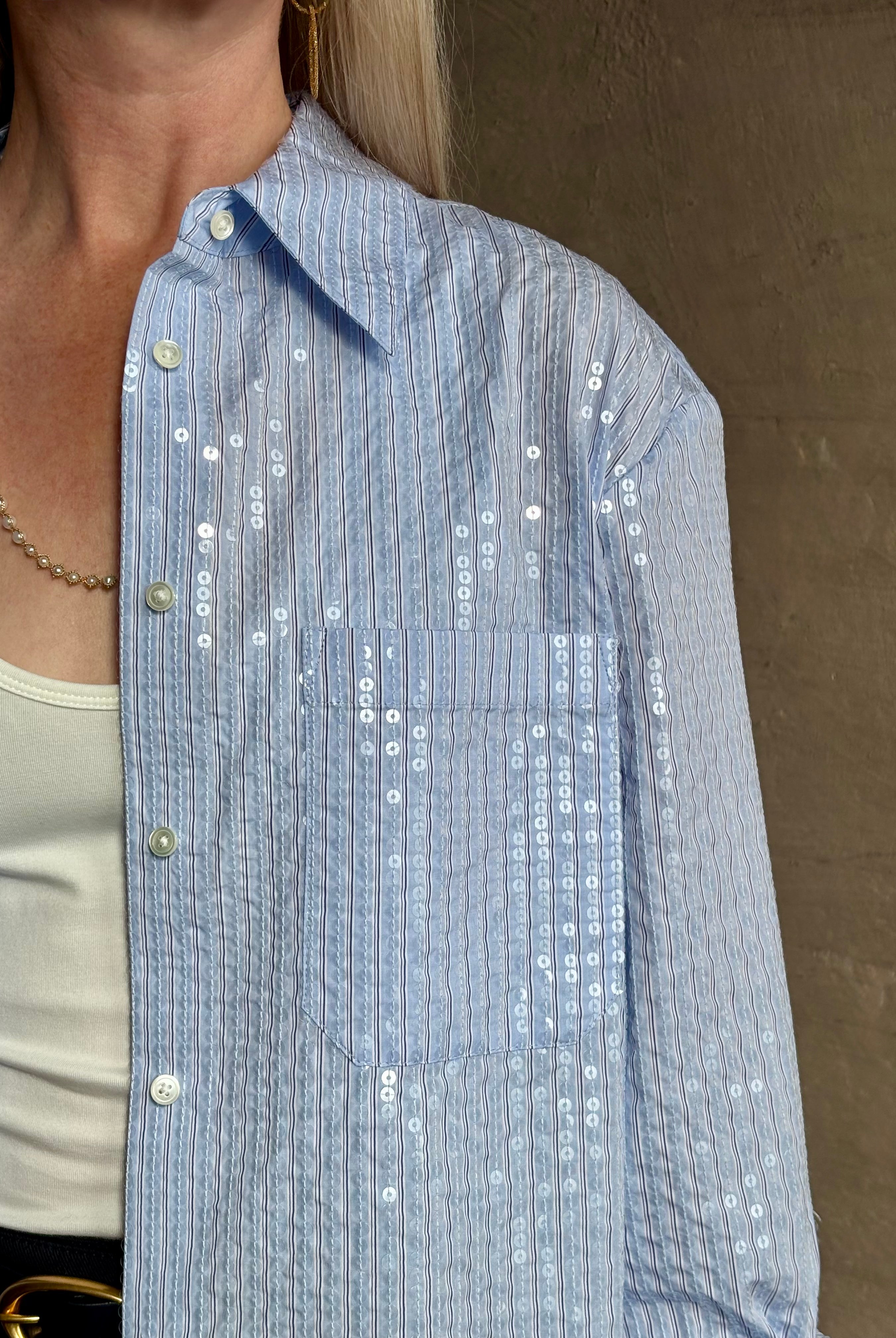 Mature woman wearing JD blue and white stripe collared button-down shirt by TWP with sequin embellishments