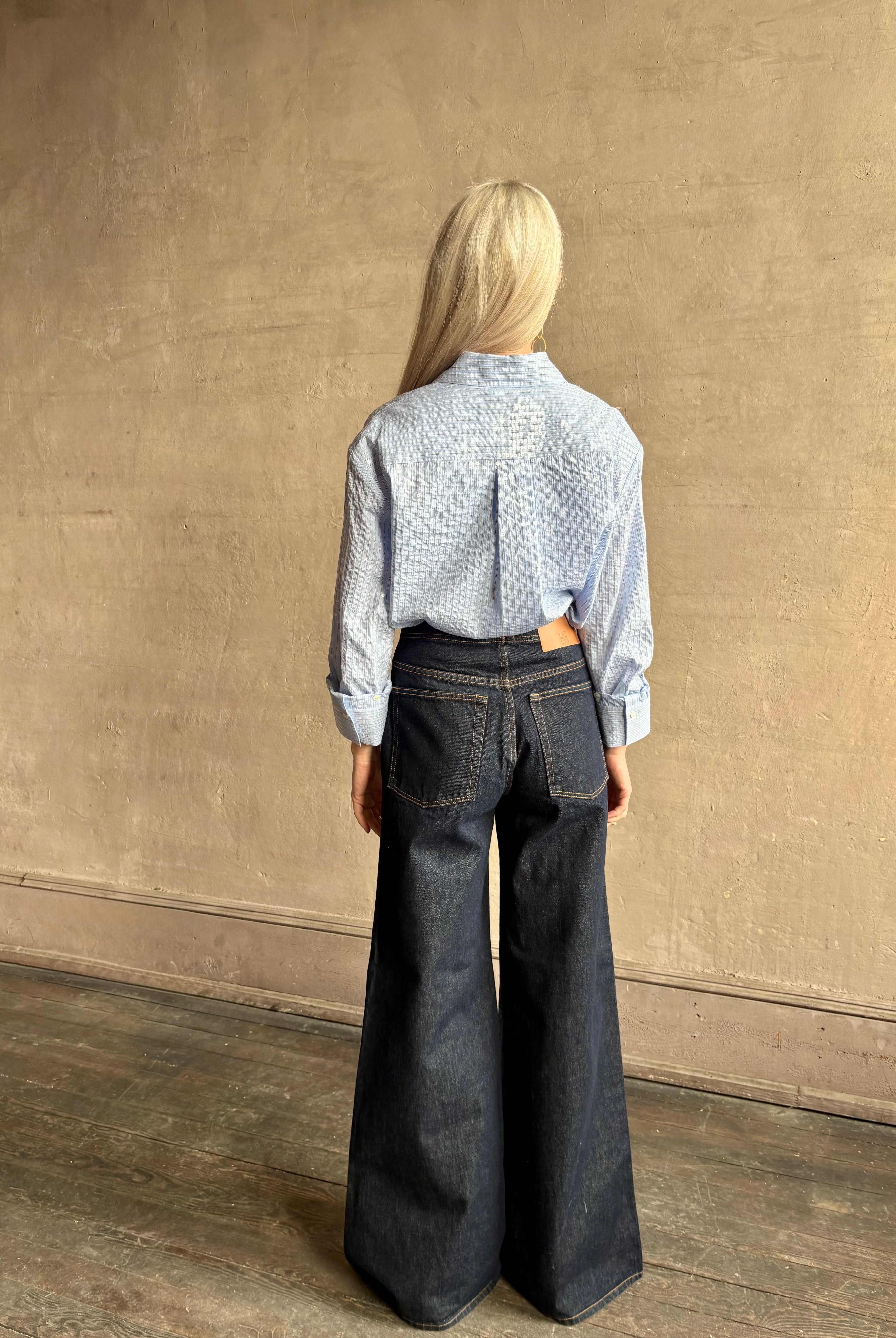 Mature woman wearing JD blue and white stripe collared button-down shirt by TWP with sequin embellishments