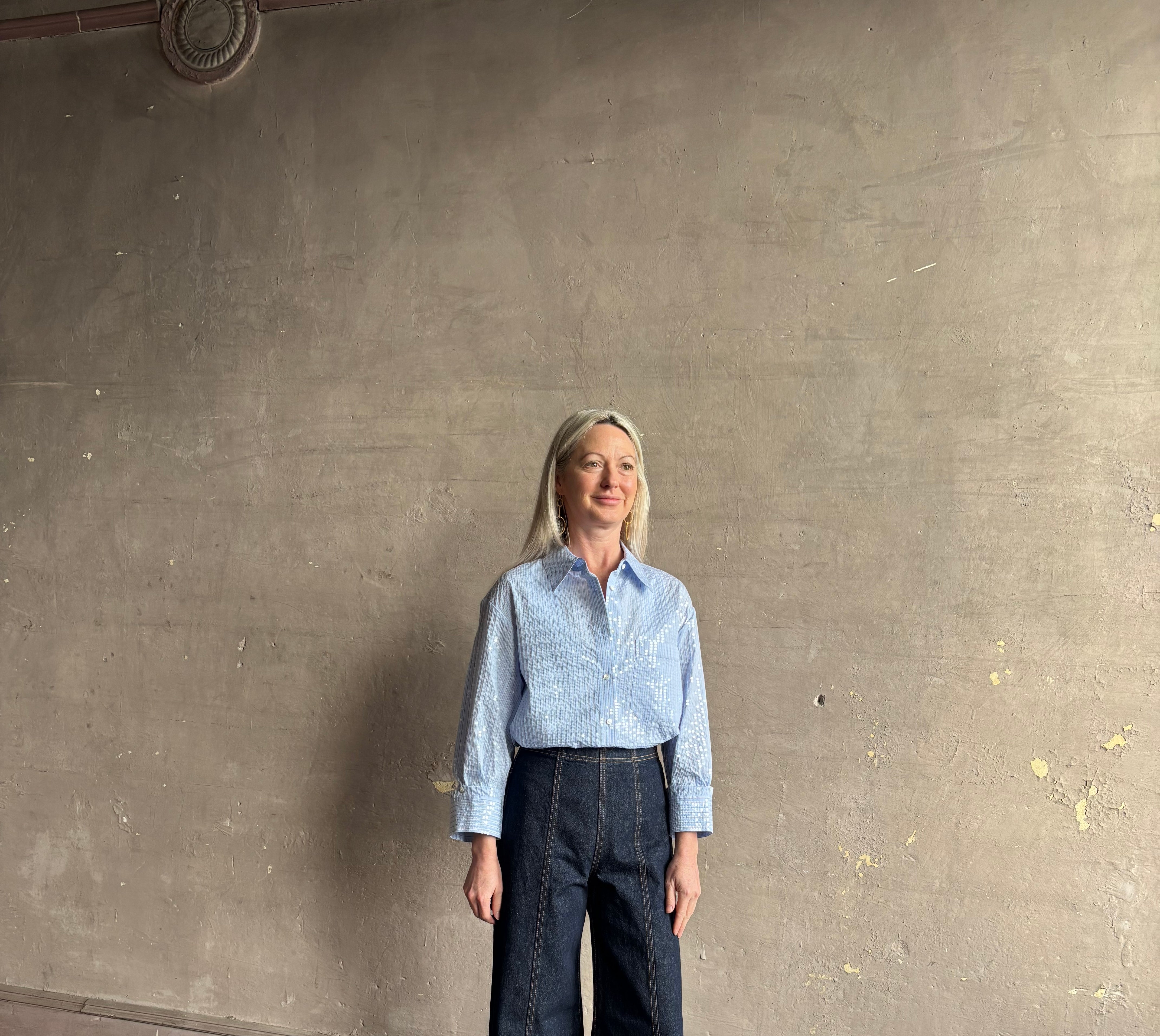 Mature woman wearing JD blue and white stripe collared button-down shirt by TWP with sequin embellishments