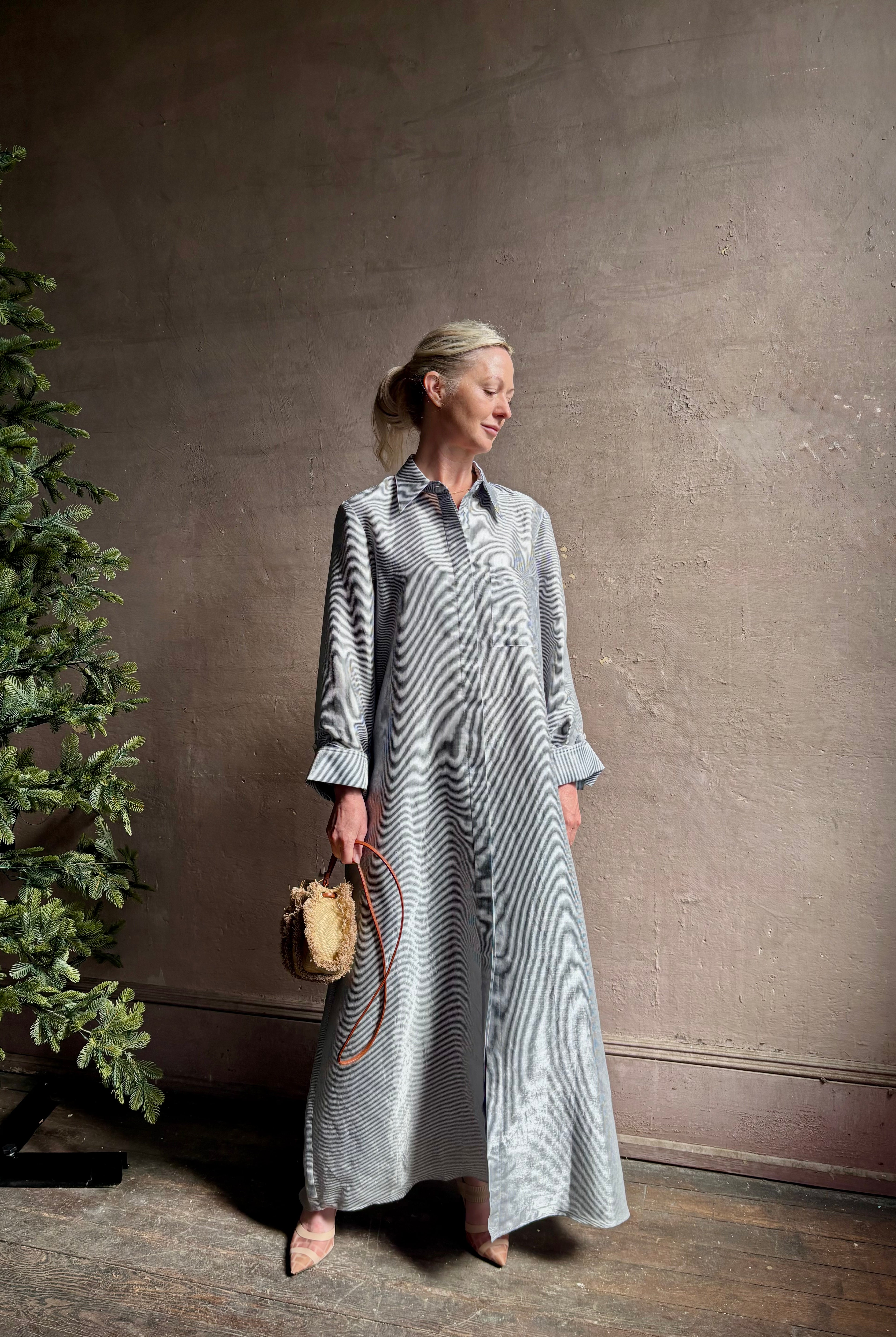 Mature woman wearing luxury Jenny's Gown from designer TWP rendered in a lumines white and blue stripe print and crafted in USA from a viscose and lorex blend this lightweight long sleeve maxi dress drapes beautifully with a flowing quality that moves with understated grace
