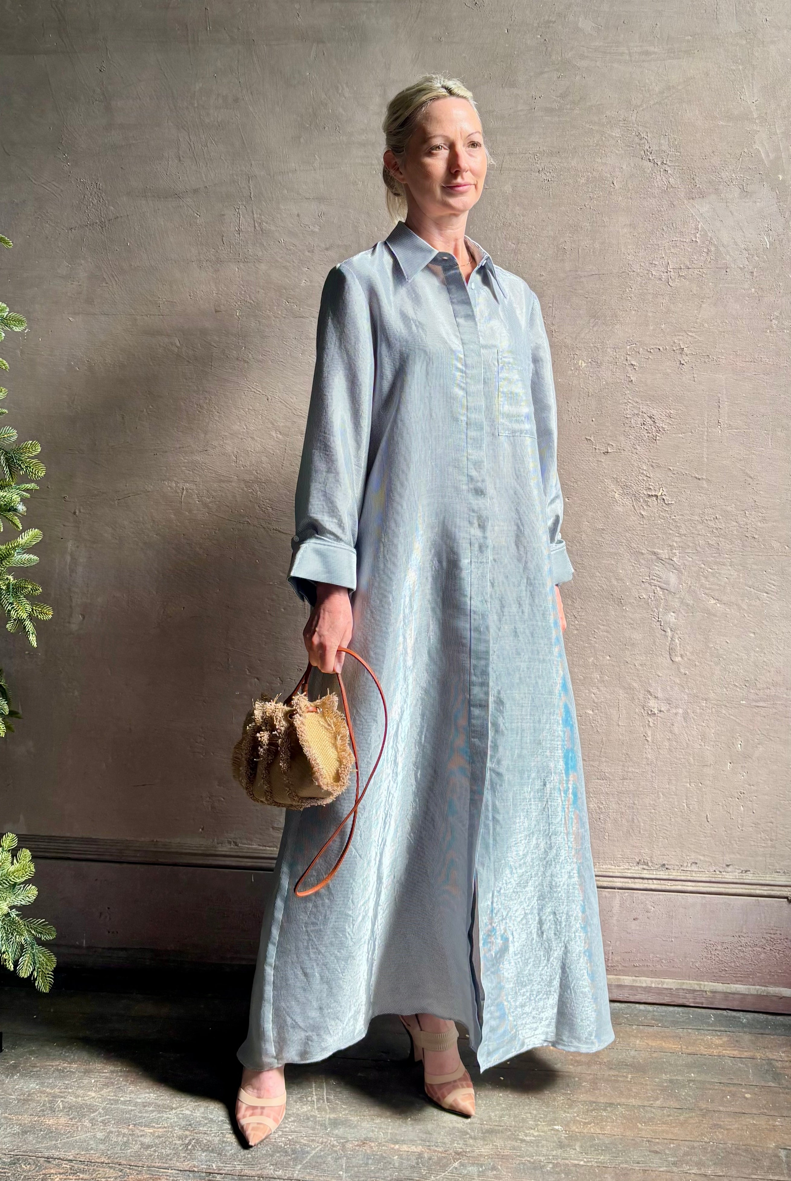Mature woman wearing luxury Jenny's Gown from designer TWP rendered in a lumines white and blue stripe print and crafted in USA from a viscose and lorex blend this lightweight long sleeve maxi dress drapes beautifully with a flowing quality that moves with understated grace