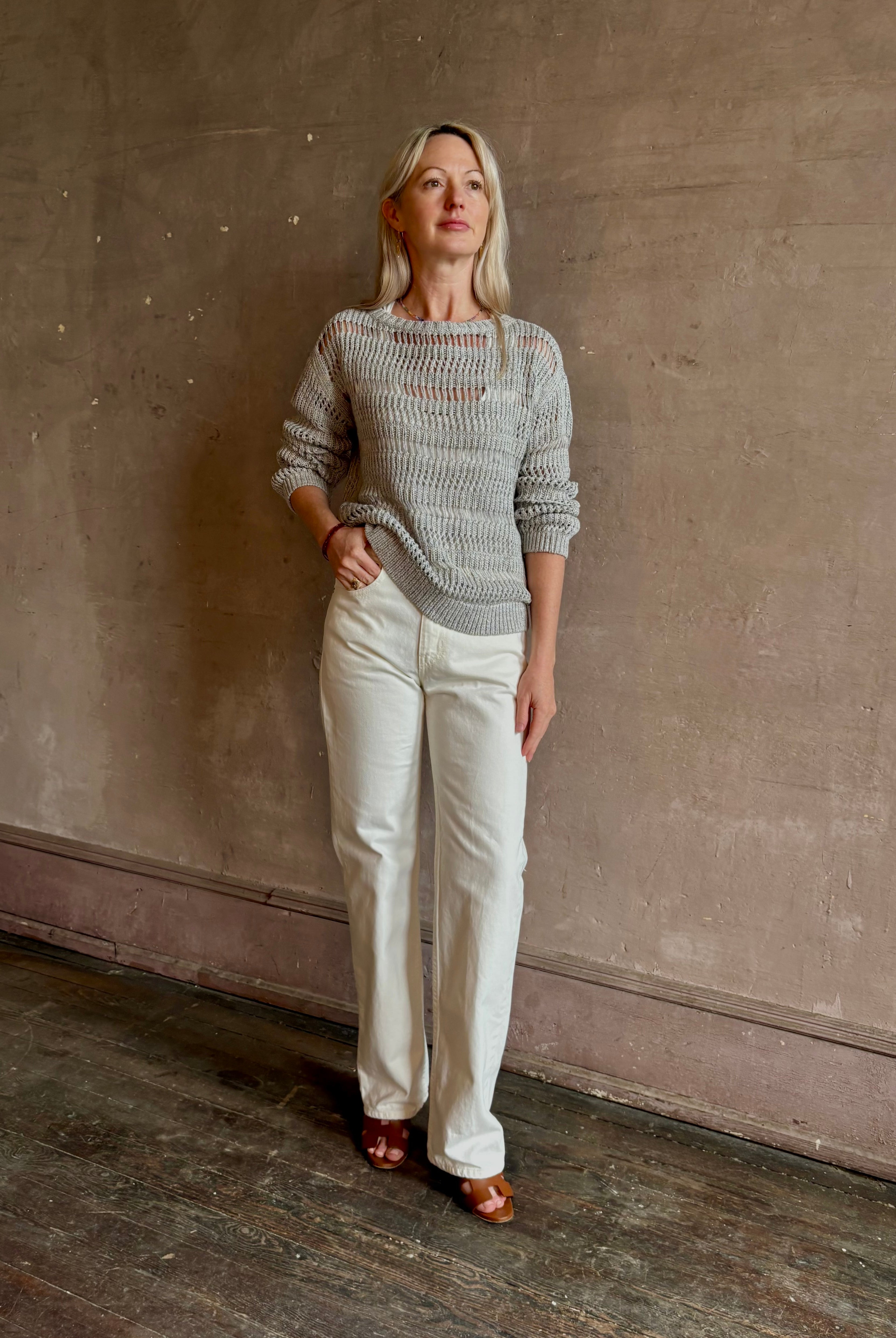 Mature woman wearing luxury Kent St modern Denim from TWP rendered in a pristine white and crafted from 100% cotton in the USA with a straight leg, high-rise and zipper closure
