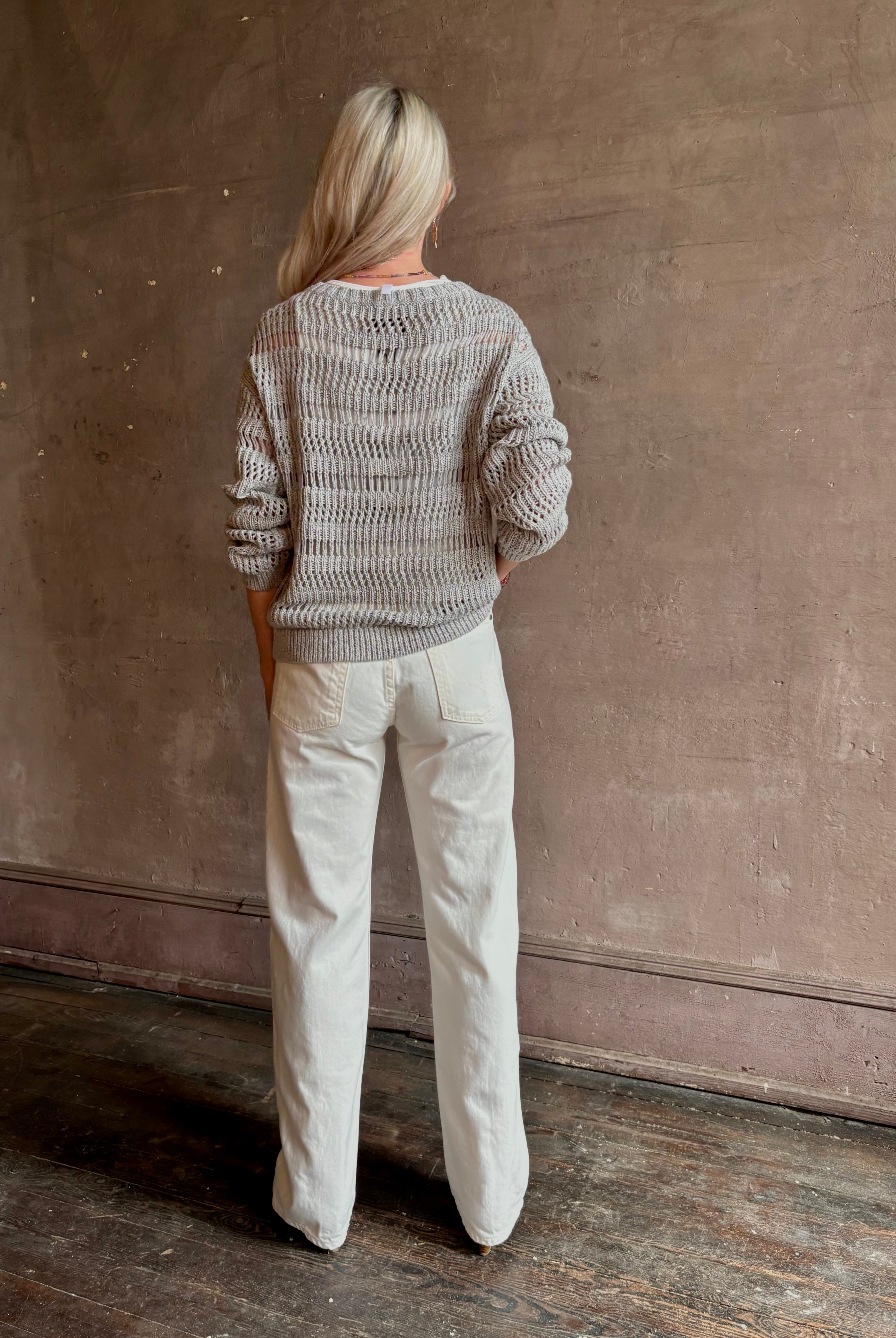 Mature woman wearing luxury Kent St modern Denim from TWP rendered in a pristine white and crafted from 100% cotton in the USA with a straight leg, high-rise and zipper closure