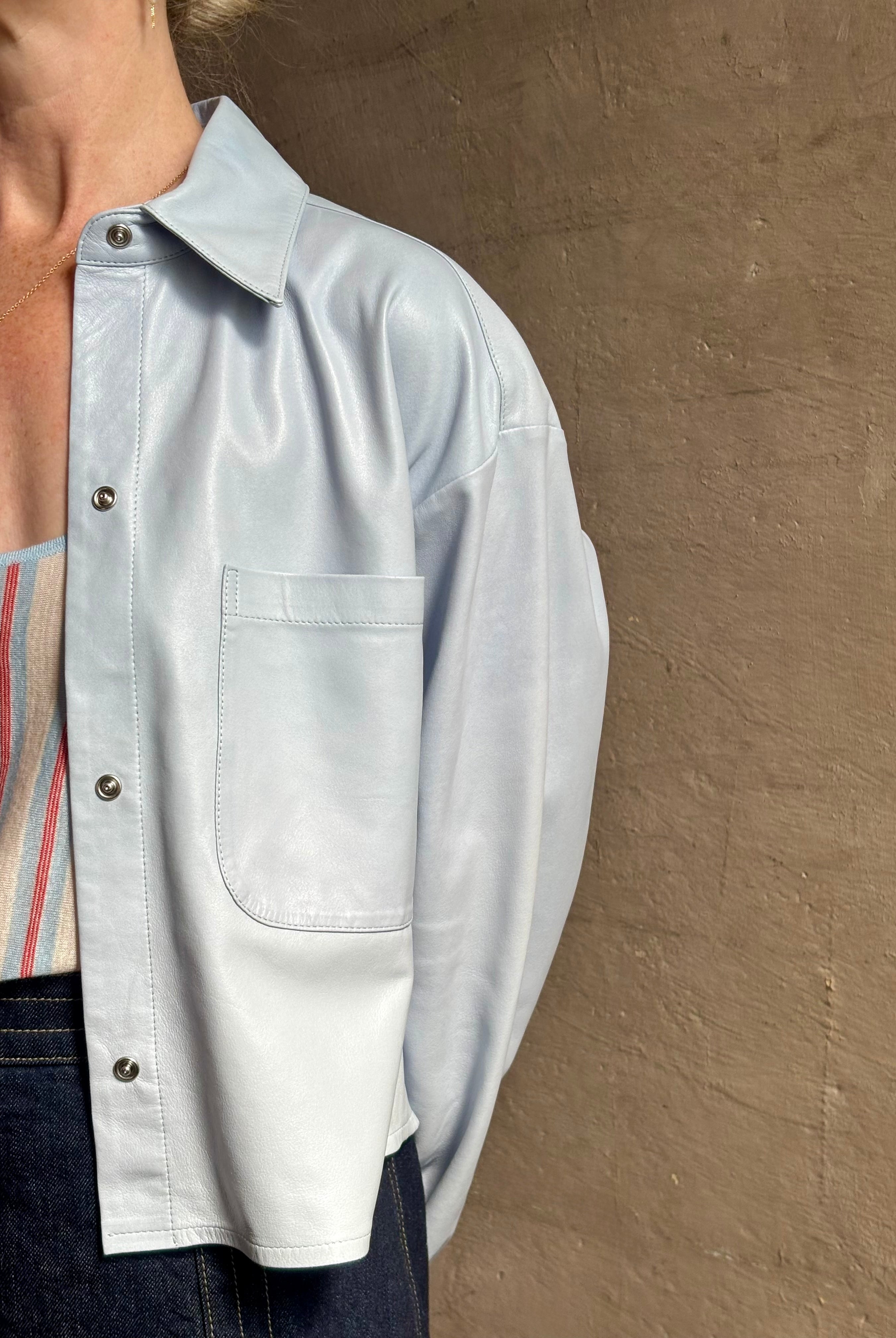 Mature woman reviewing premium lambskin leather TWP Little Big Joe button down cropped Shirt or Jacket in Kentucky Blue with long sleeves
