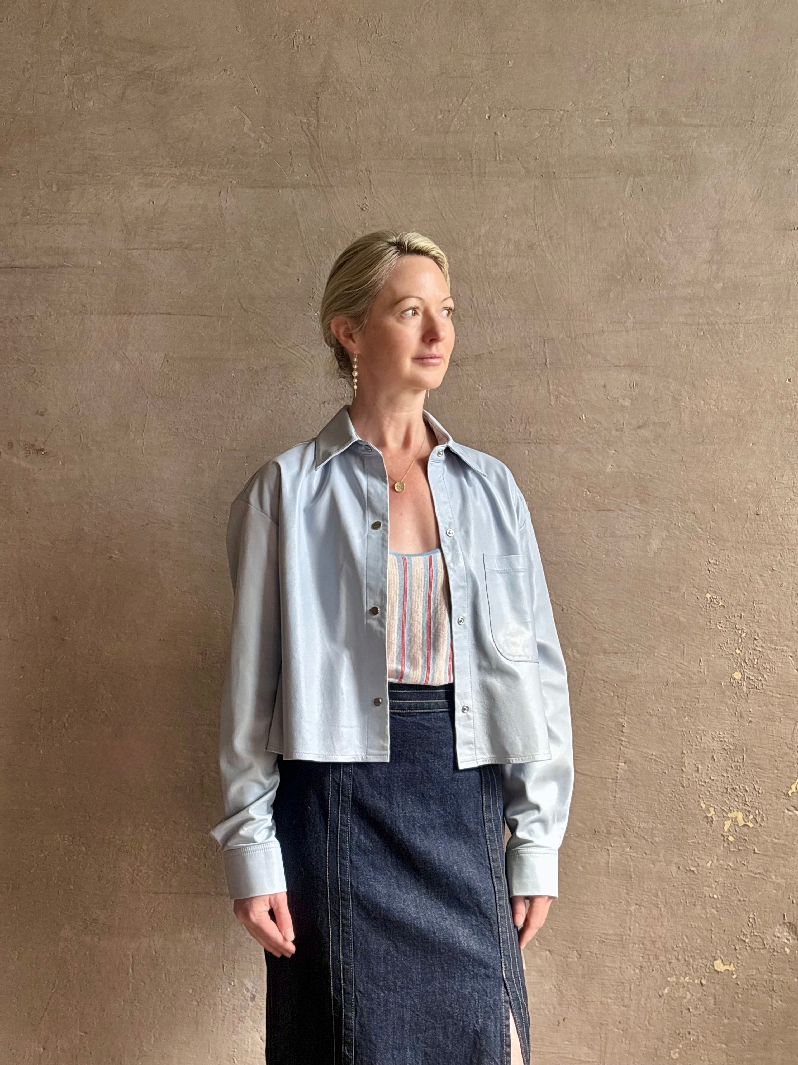 Mature woman reviewing premium lambskin leather TWP Little Big Joe button down cropped Shirt or Jacket in Kentucky Blue with long sleeves