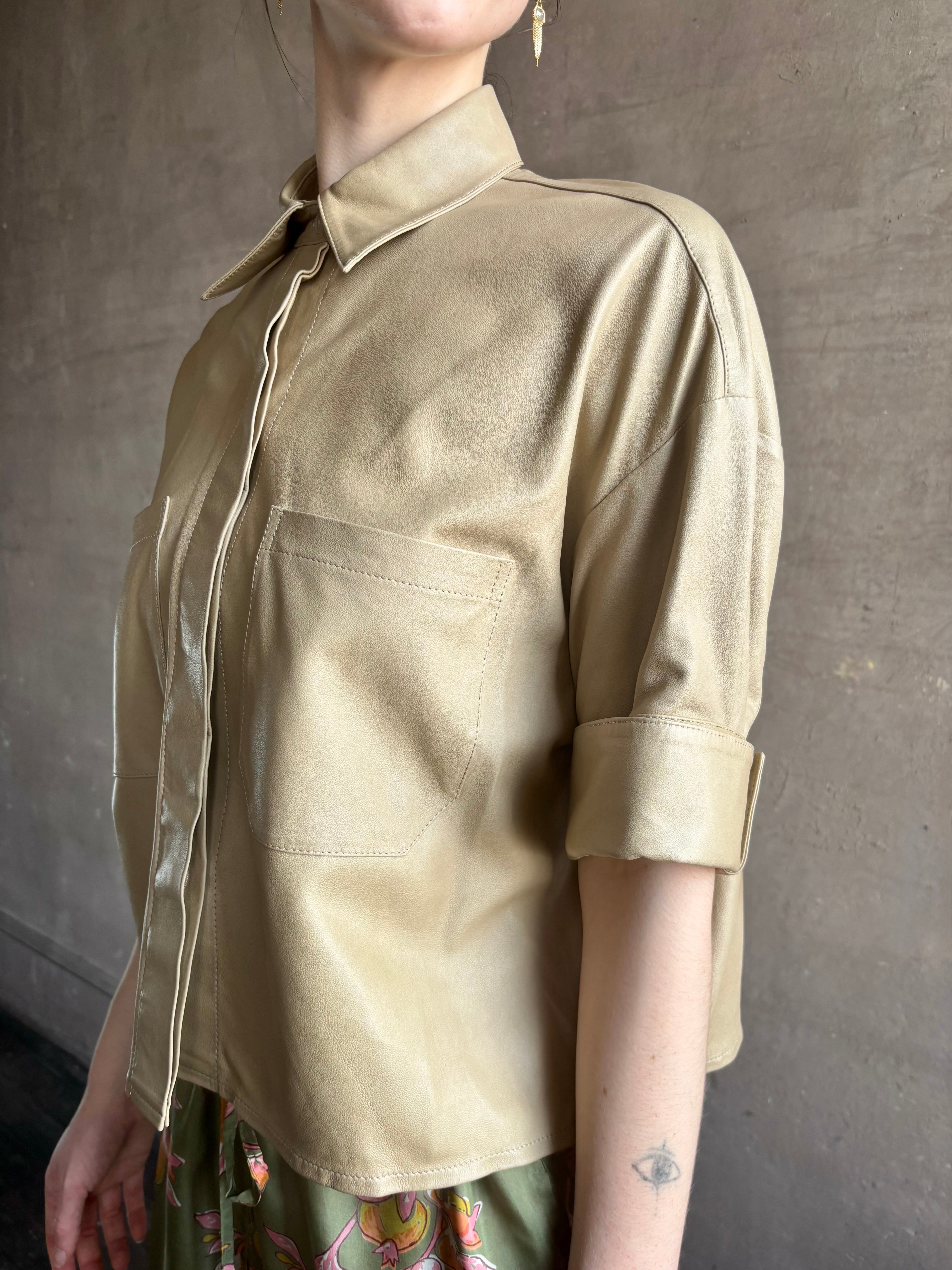 Woman wearing luxury designer TWP premium Lambskin Leather button up collared shirt with cuffed short sleeves in a neutral khaki that can double as a lightweight jacket