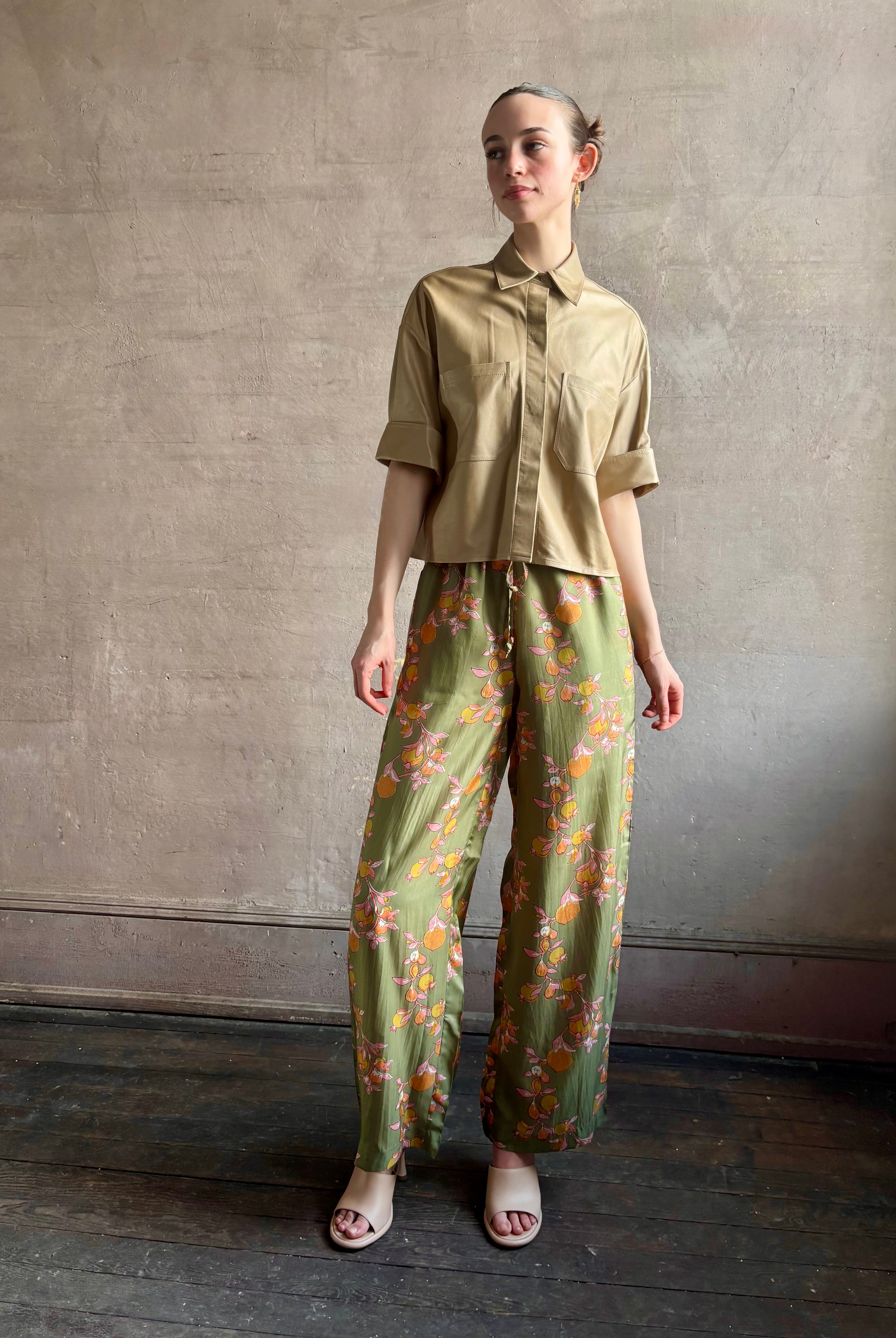 Woman wearing luxury designer TWP premium Lambskin Leather button up collared shirt with cuffed short sleeves in a neutral khaki that can double as a lightweight jacket