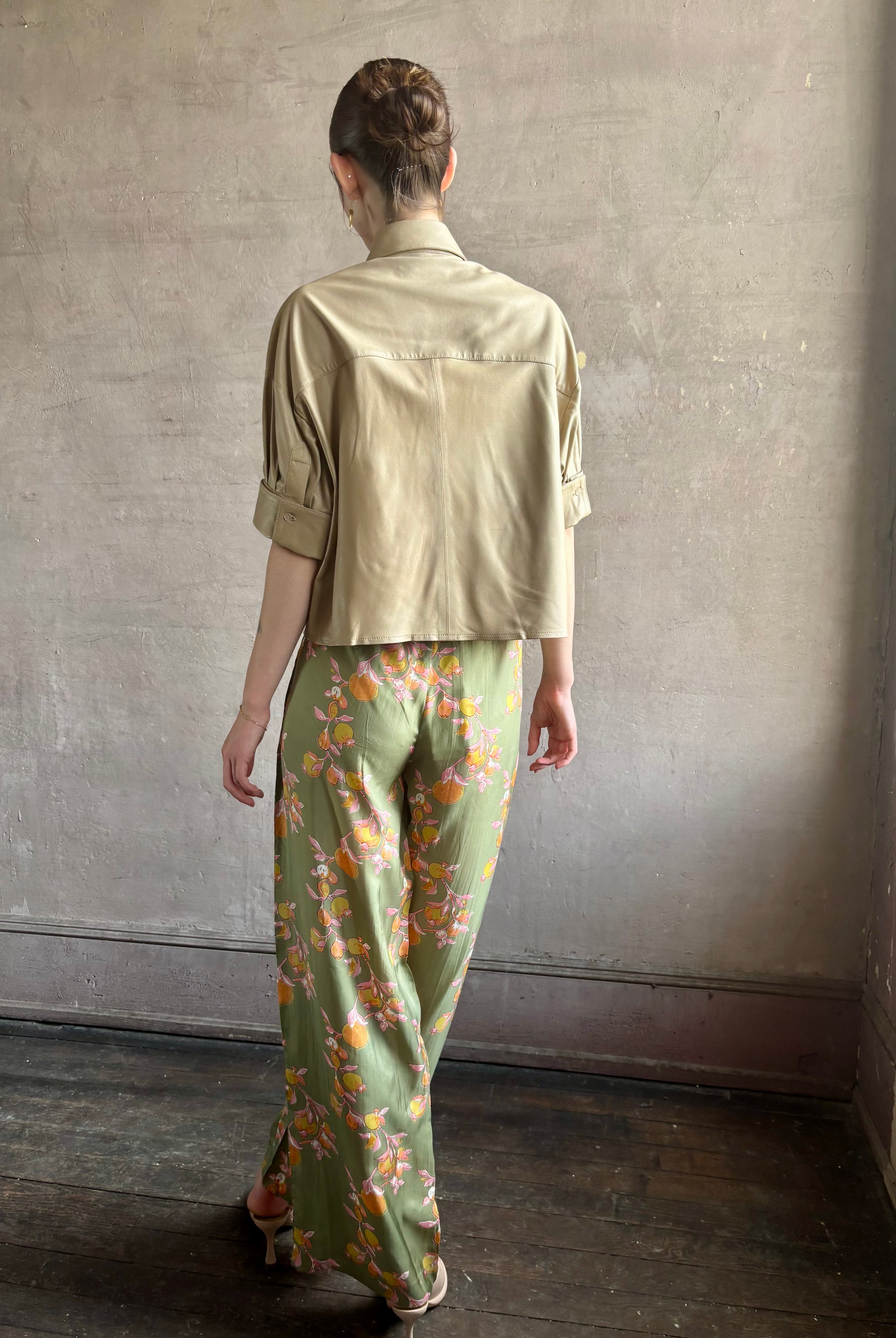 Woman wearing luxury designer TWP premium Lambskin Leather button up collared shirt with cuffed short sleeves in a neutral khaki that can double as a lightweight jacket