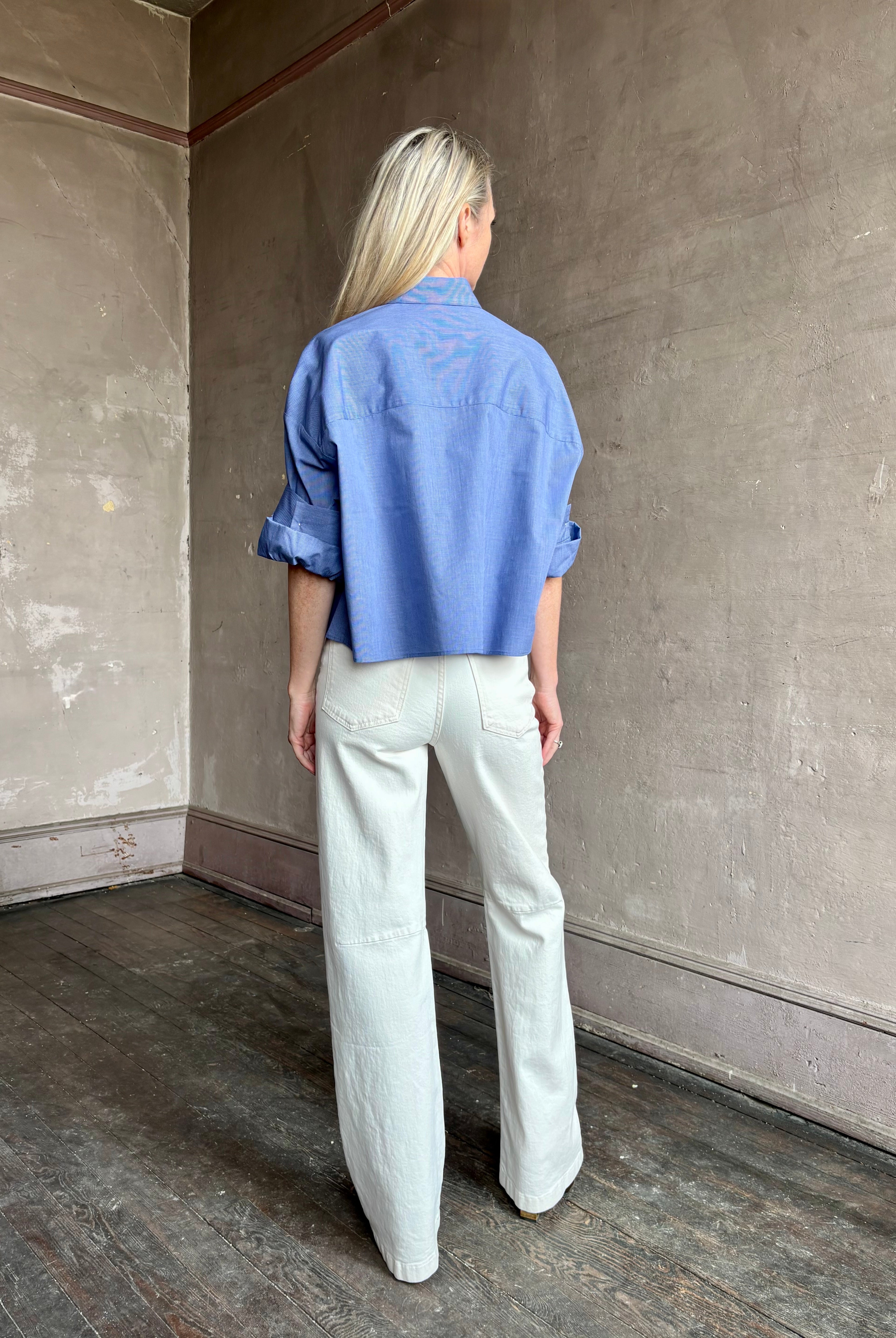 Image of mature model wearing classic cotton poplin button down next ex top by luxury brand TWP in a blue and white stripe.