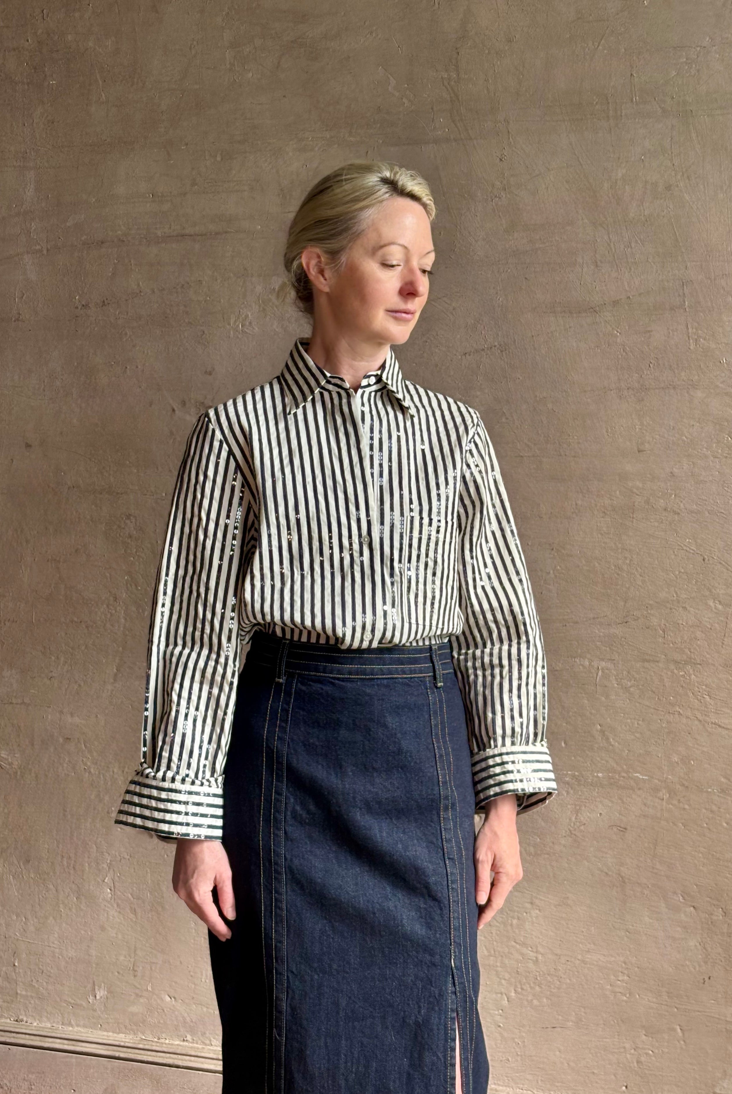 Mature woman wearing TWP premium cotton-blend button down indigo striped shirt with sequins, long sleeve and collar