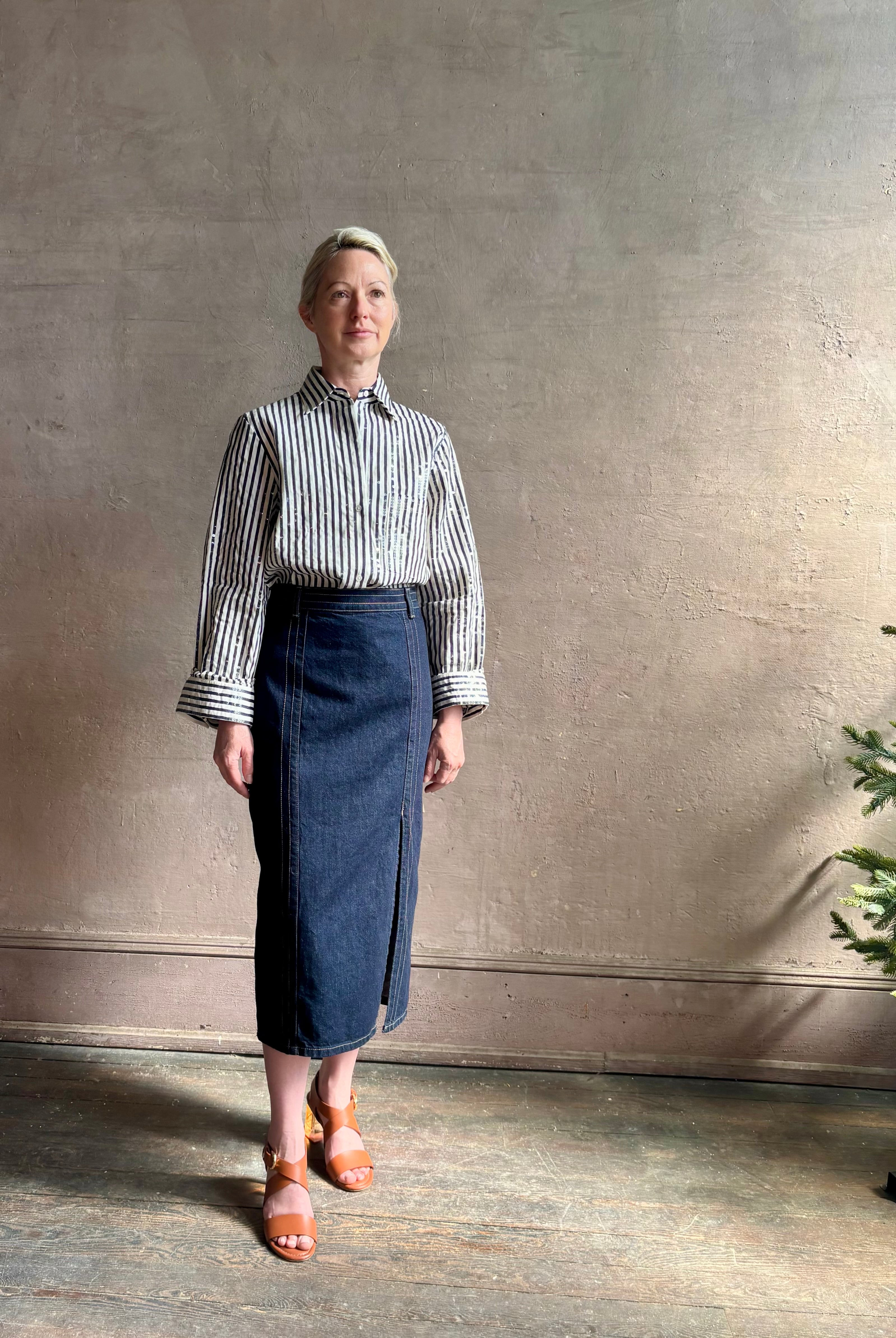 Mature woman wearing TWP premium cotton-blend button down indigo striped shirt with sequins, long sleeve and collar