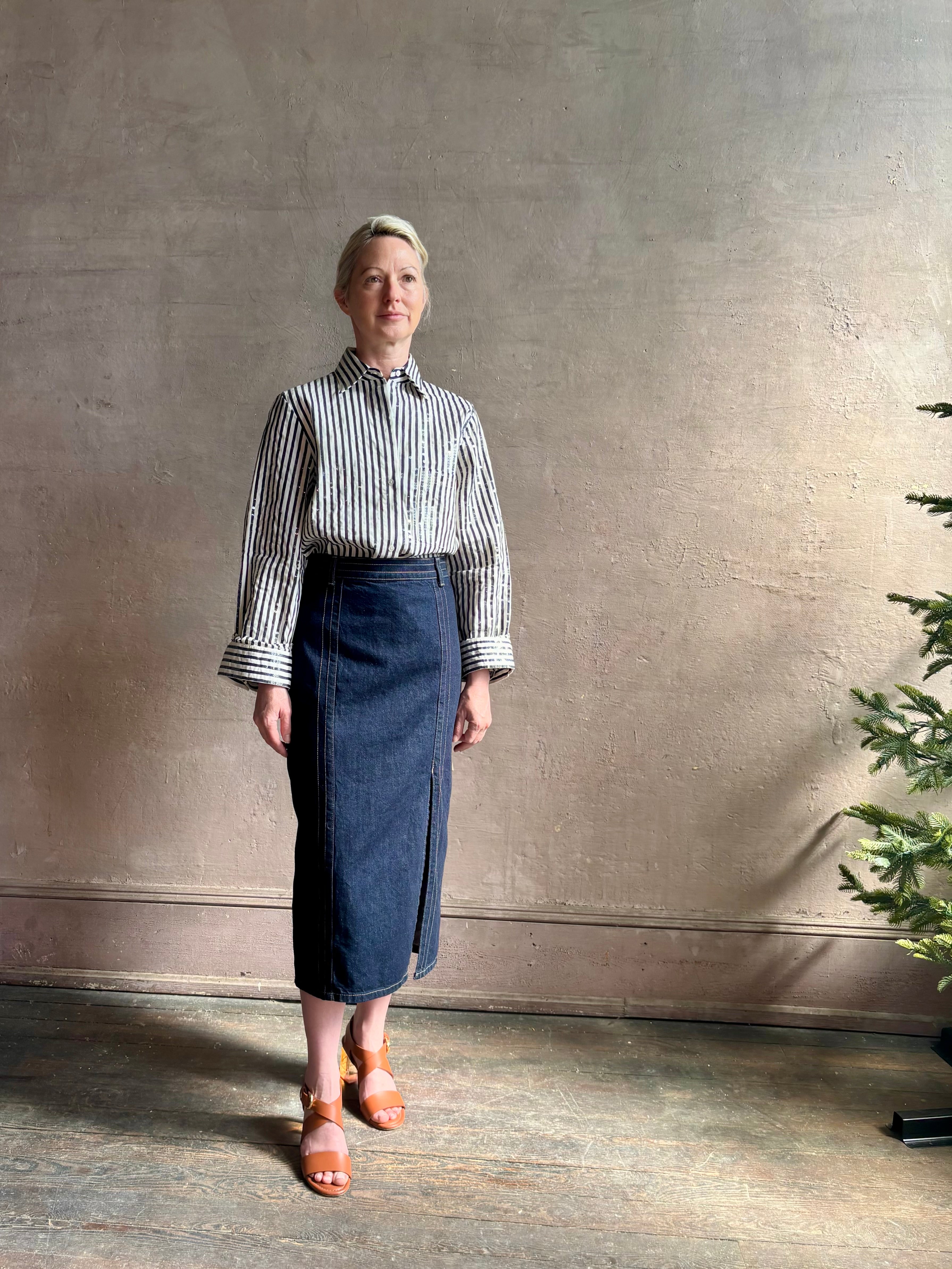 Mature woman wearing TWP premium cotton-blend button down indigo striped shirt with sequins, long sleeve and collar