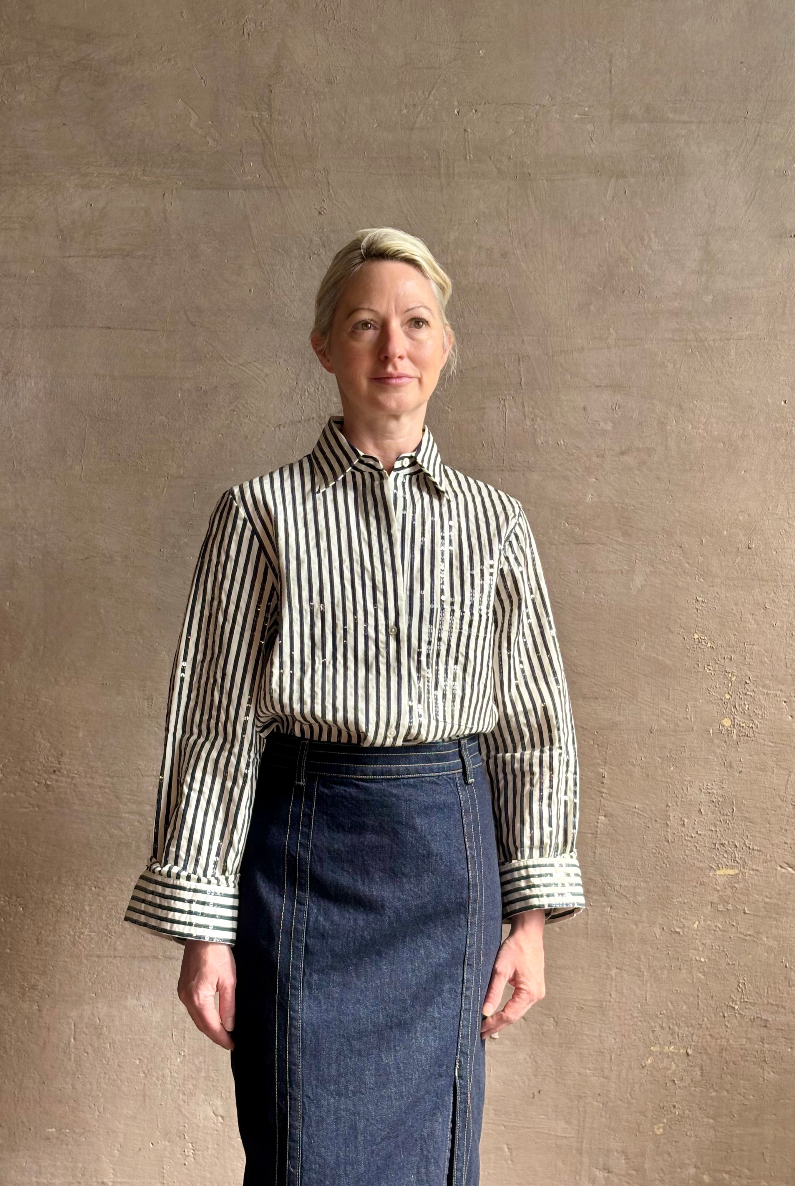 Mature woman wearing TWP premium cotton-blend button down indigo striped shirt with sequins, long sleeve and collar